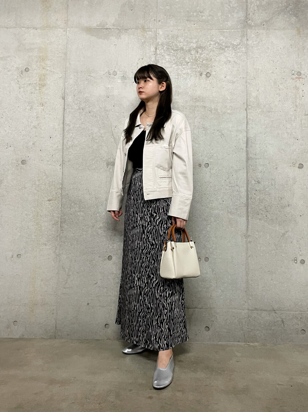 ホワイト系のその他アウター、ブラック系のタンクトップ、ブラック系のスカートを着用したレディースの秋コーディネートの1枚目の写真