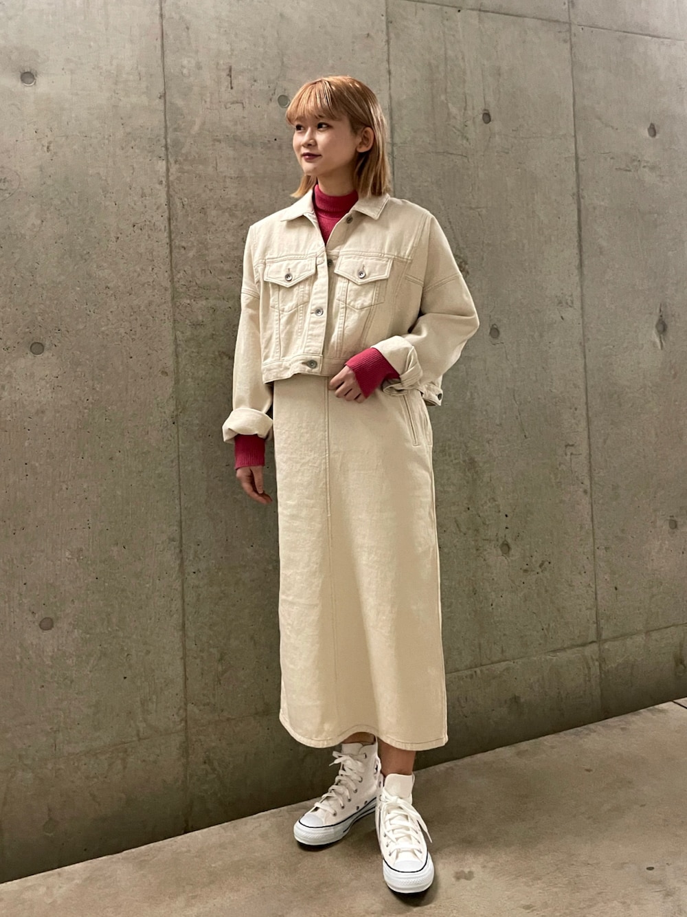 ホワイト系のジャンパースカート、ホワイト系のデニムジャケット、ピンク系のニット/セーターを着用したレディースの冬コーディネートの1枚目の写真