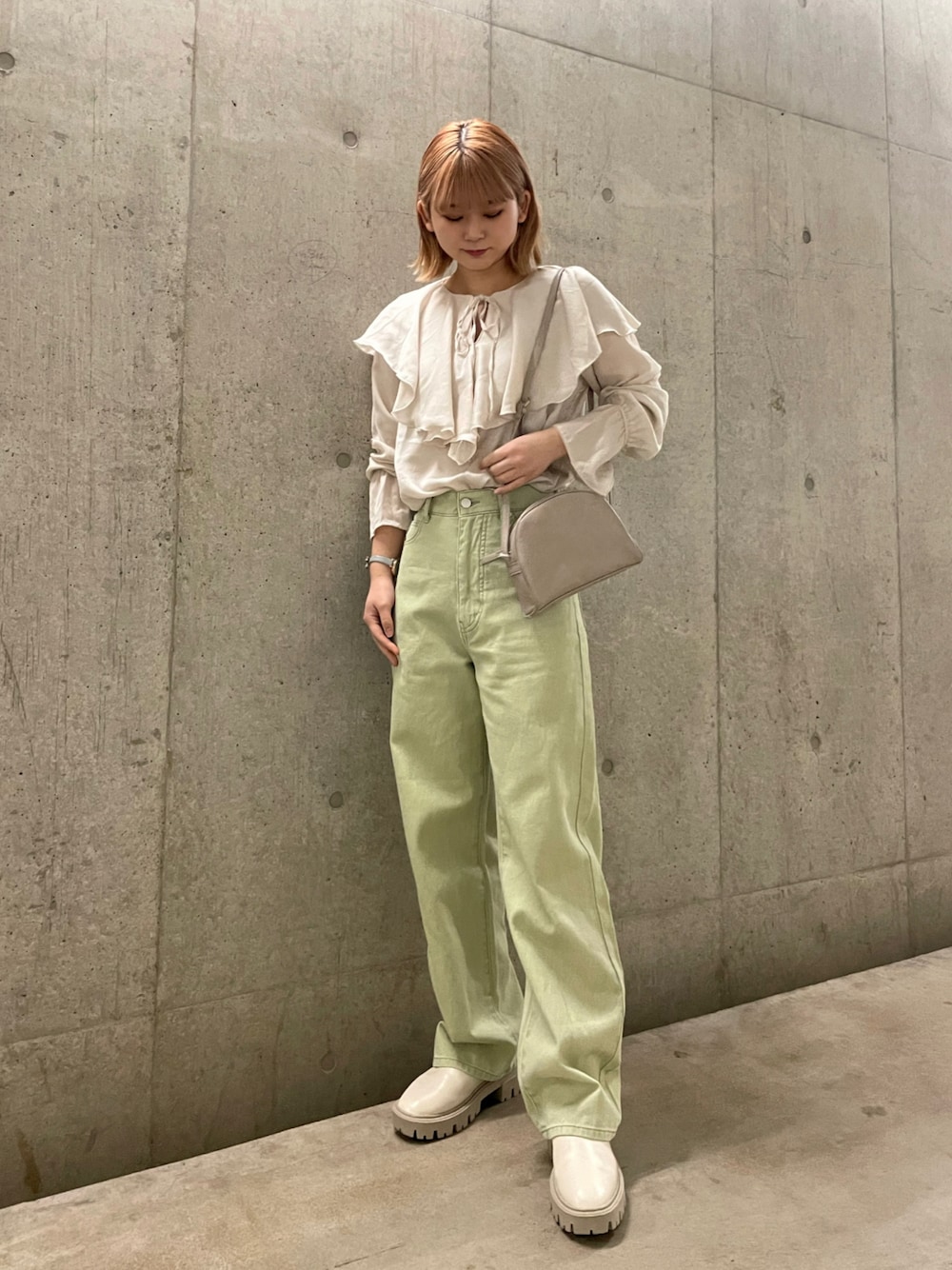 グリーン系のデニムジャケット、ホワイト系のブーツ、グリーン系のデニムパンツを着用したレディースの冬コーディネートの1枚目の写真