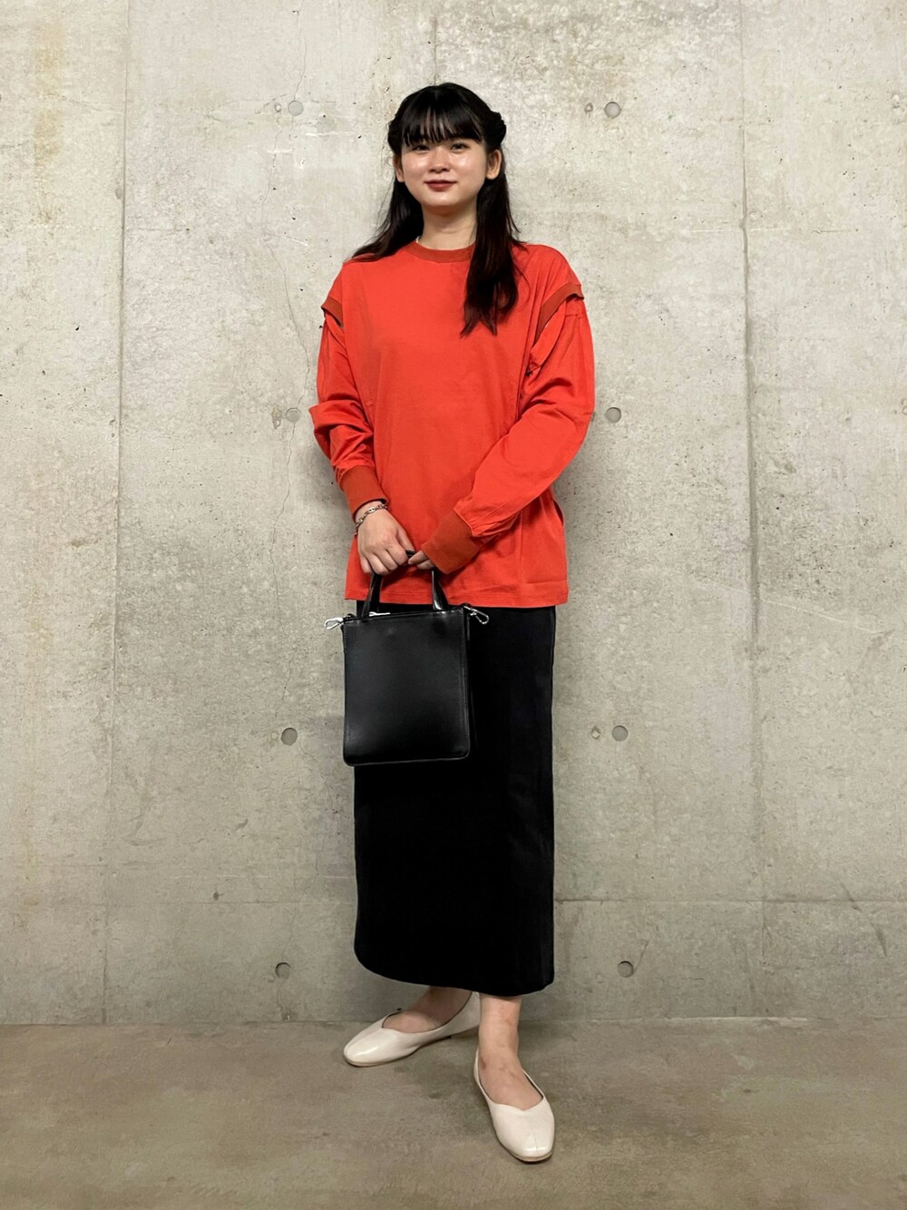 オレンジ系のTシャツ/カットソー、ブラック系のショルダーバッグ、ブルー系のスカートを着用したレディースの夏コーディネートの1枚目の写真
