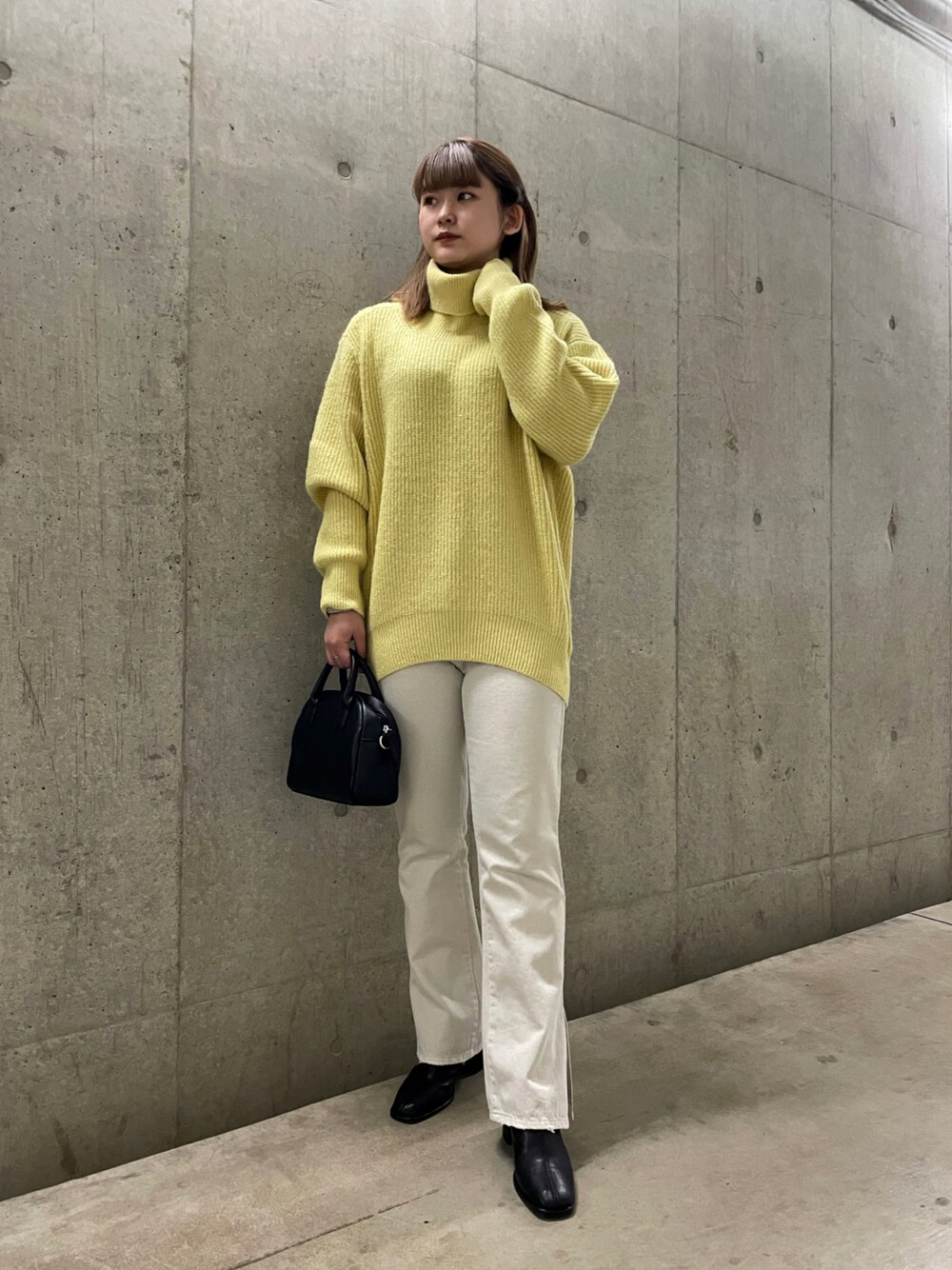 ブラック系のショルダーバッグ、イエロー系のニット/セーター、ホワイト系のその他パンツを着用したレディースの秋コーディネートの1枚目の写真