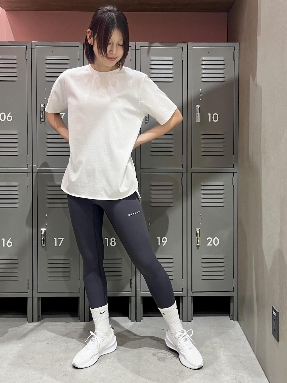 ホワイト系のTシャツ/カットソー、ホワイト系のスニーカー、グレー系のレギンス/スパッツを着用したレディースの冬コーディネートの1枚目の写真