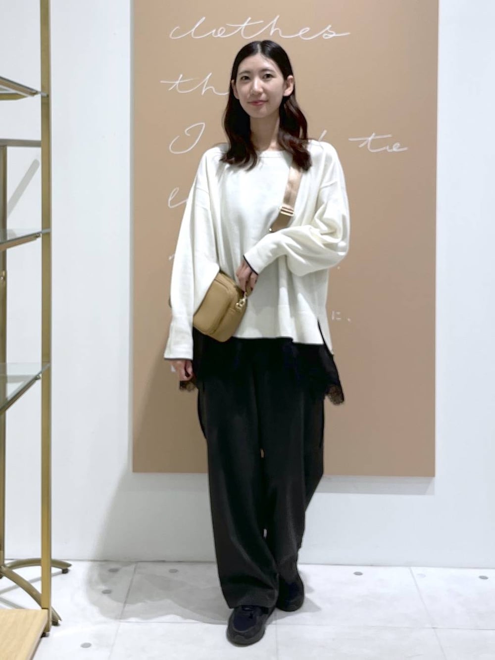 グレー系のカーゴパンツ、イエロー系のショルダーバッグ、ブラック系のキャミソールを着用したレディースの秋コーディネートの1枚目の写真