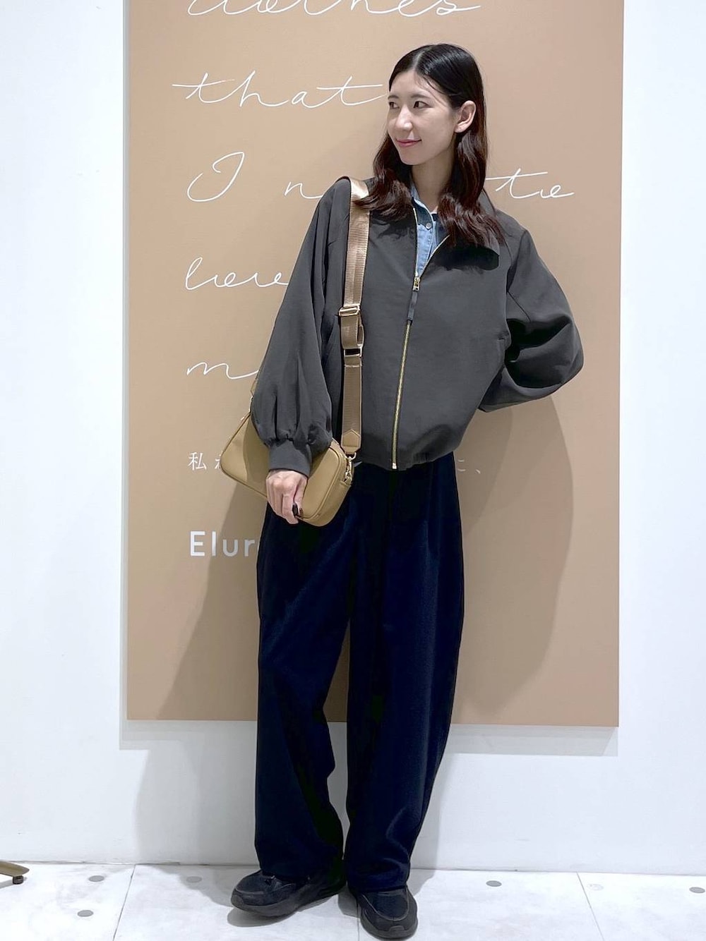 グレー系のブルゾン、ブルー系のその他パンツ、イエロー系のショルダーバッグを着用したレディースの秋コーディネートの1枚目の写真