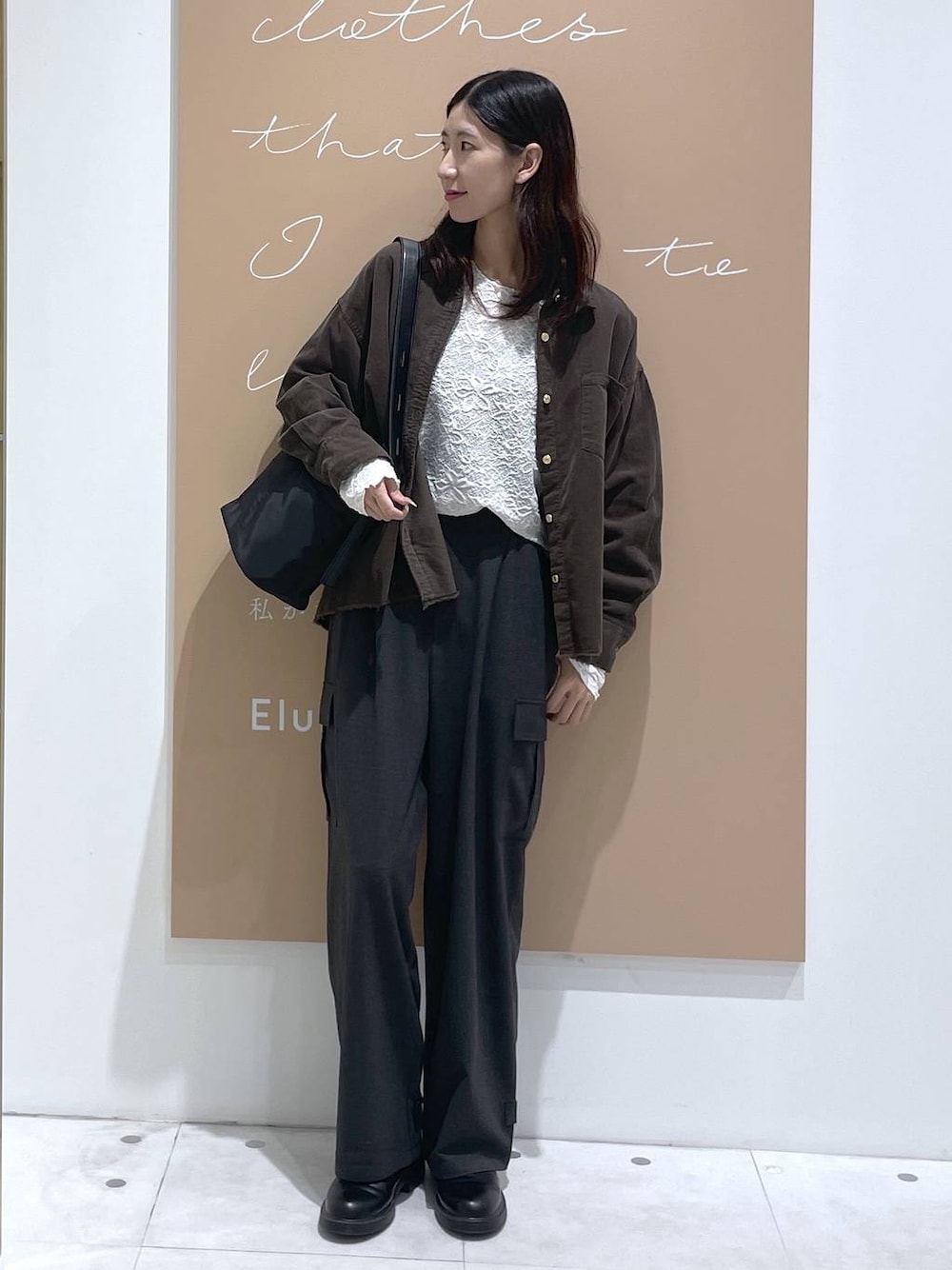 ブラック系のショルダーバッグ、グレー系のシャツ/ブラウス、ホワイト系のTシャツ/カットソーを着用したレディースの秋コーディネートの1枚目の写真