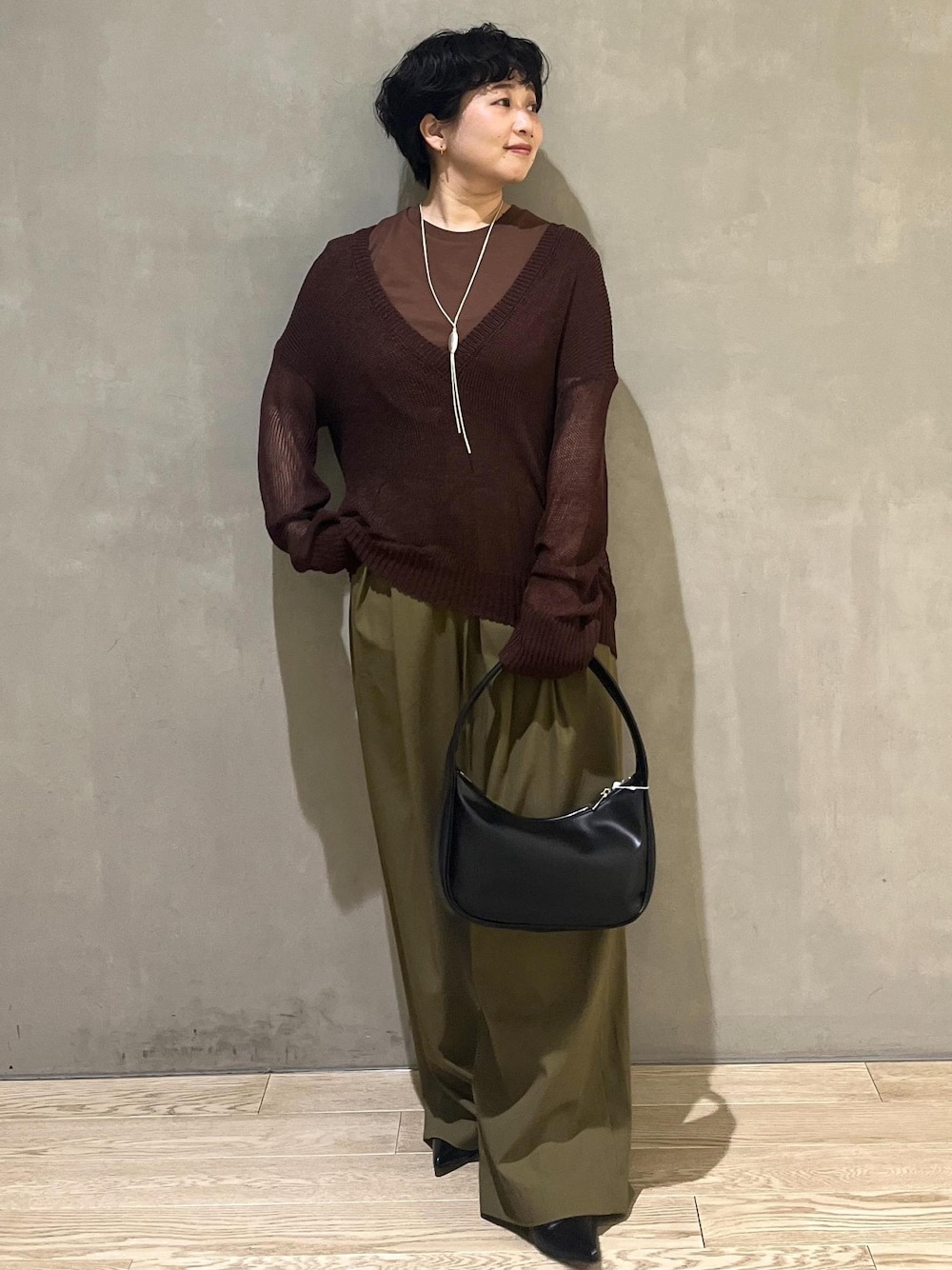 ブラック系のハンドバッグ、グリーン系のその他パンツ、ブラウン系のTシャツ/カットソーを着用したレディースの夏コーディネートの1枚目の写真