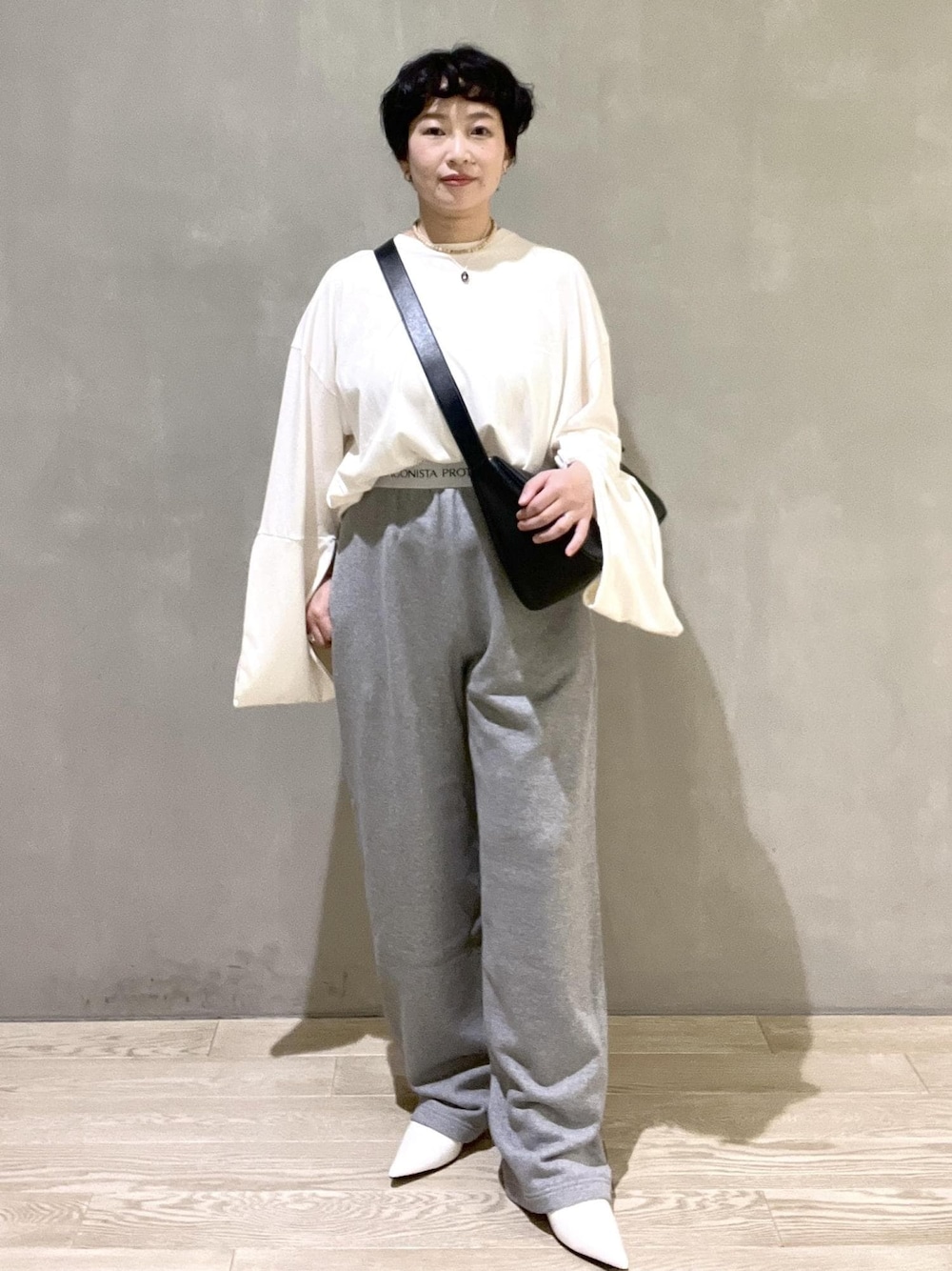 ブラック系のショルダーバッグ、ホワイト系のTシャツ/カットソー、ホワイト系のパンプスを着用したレディースの夏コーディネートの1枚目の写真