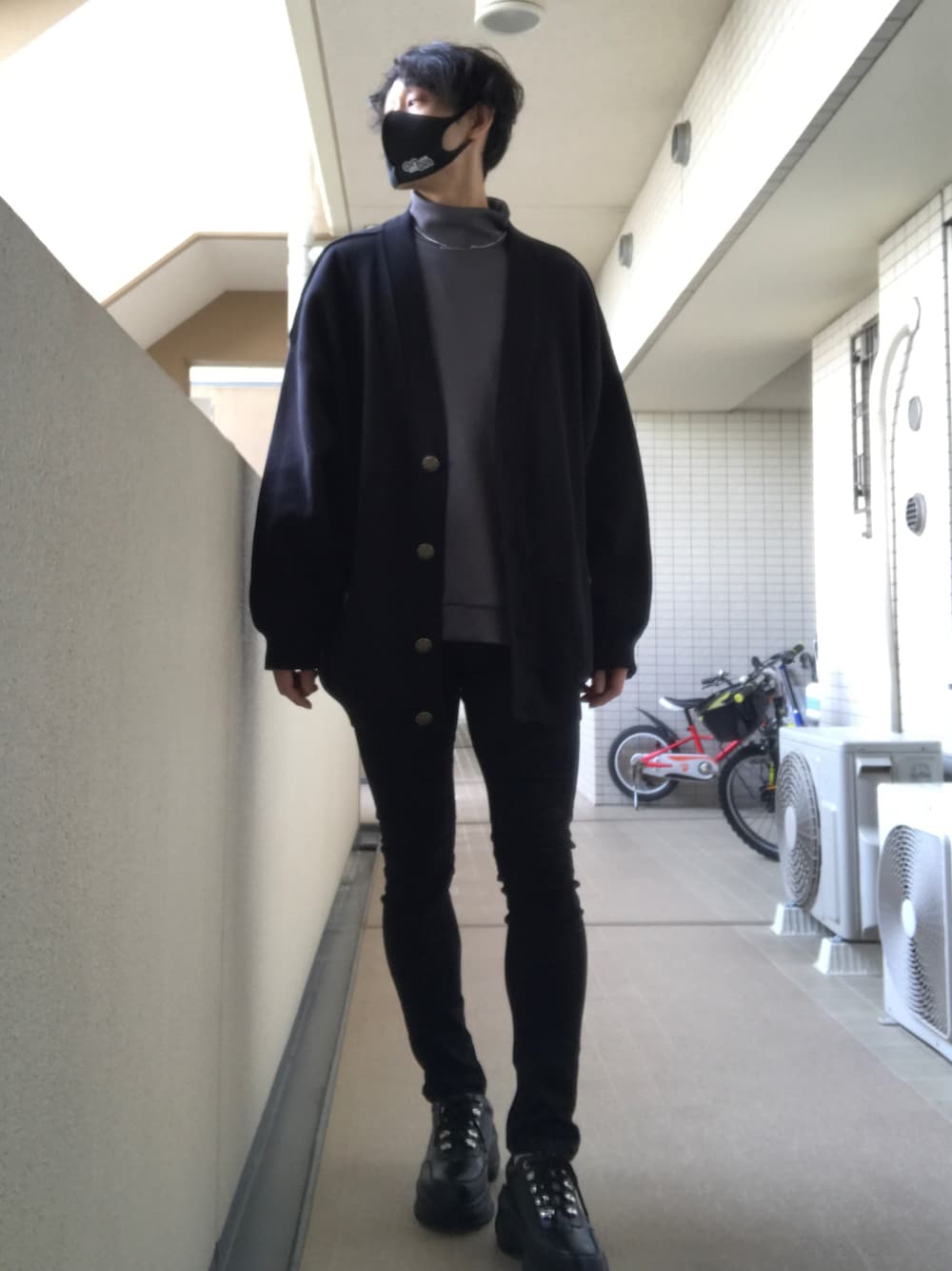 ブラック系のカーディガン/ボレロ、グレー系のトップス、ブラック系のデニムパンツを着用したメンズの冬コーディネートの1枚目の写真