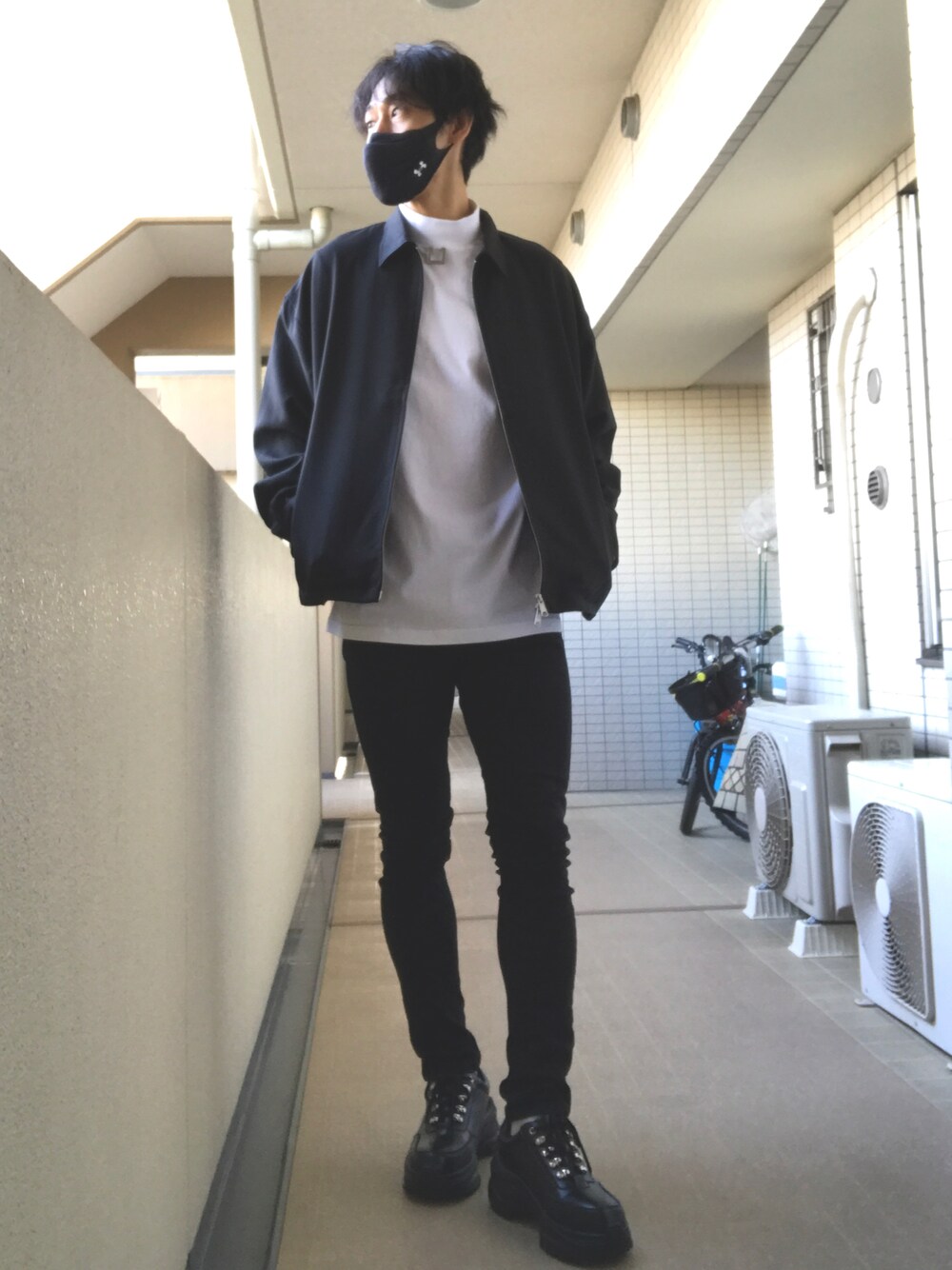 ブラック系のブルゾン、ホワイト系のTシャツ/カットソー、ブラック系のデニムパンツを着用したメンズの秋コーディネートの1枚目の写真