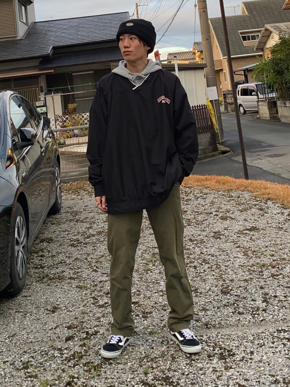 グリーン系のチノパンツ、ブラック系のスニーカー、グレー系のパーカーを着用したメンズの冬コーディネートの1枚目の写真