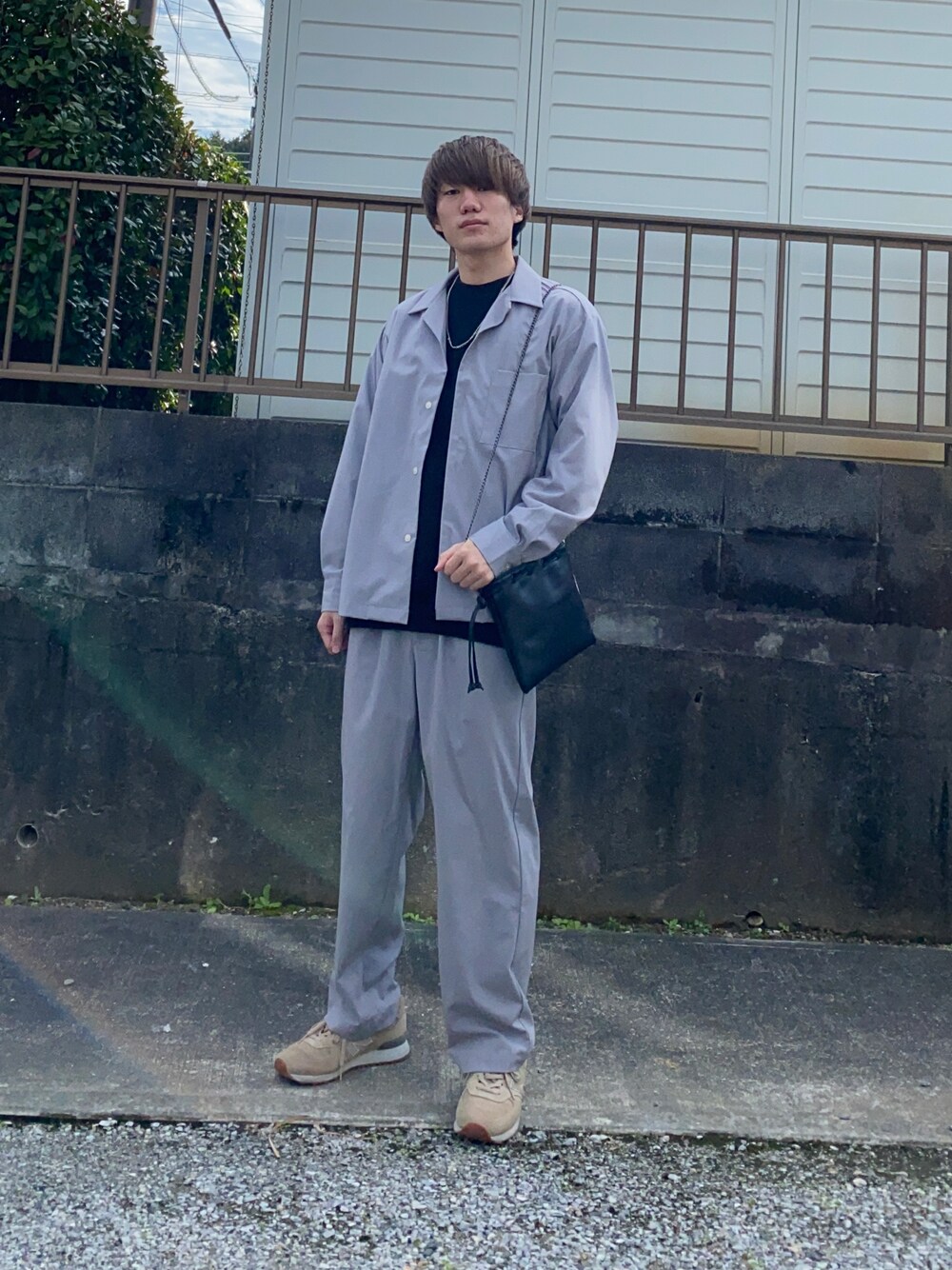 ブラック系のニット/セーター、ブラック系のバッグ、ベージュ系のスニーカーを着用したメンズの冬コーディネートの1枚目の写真