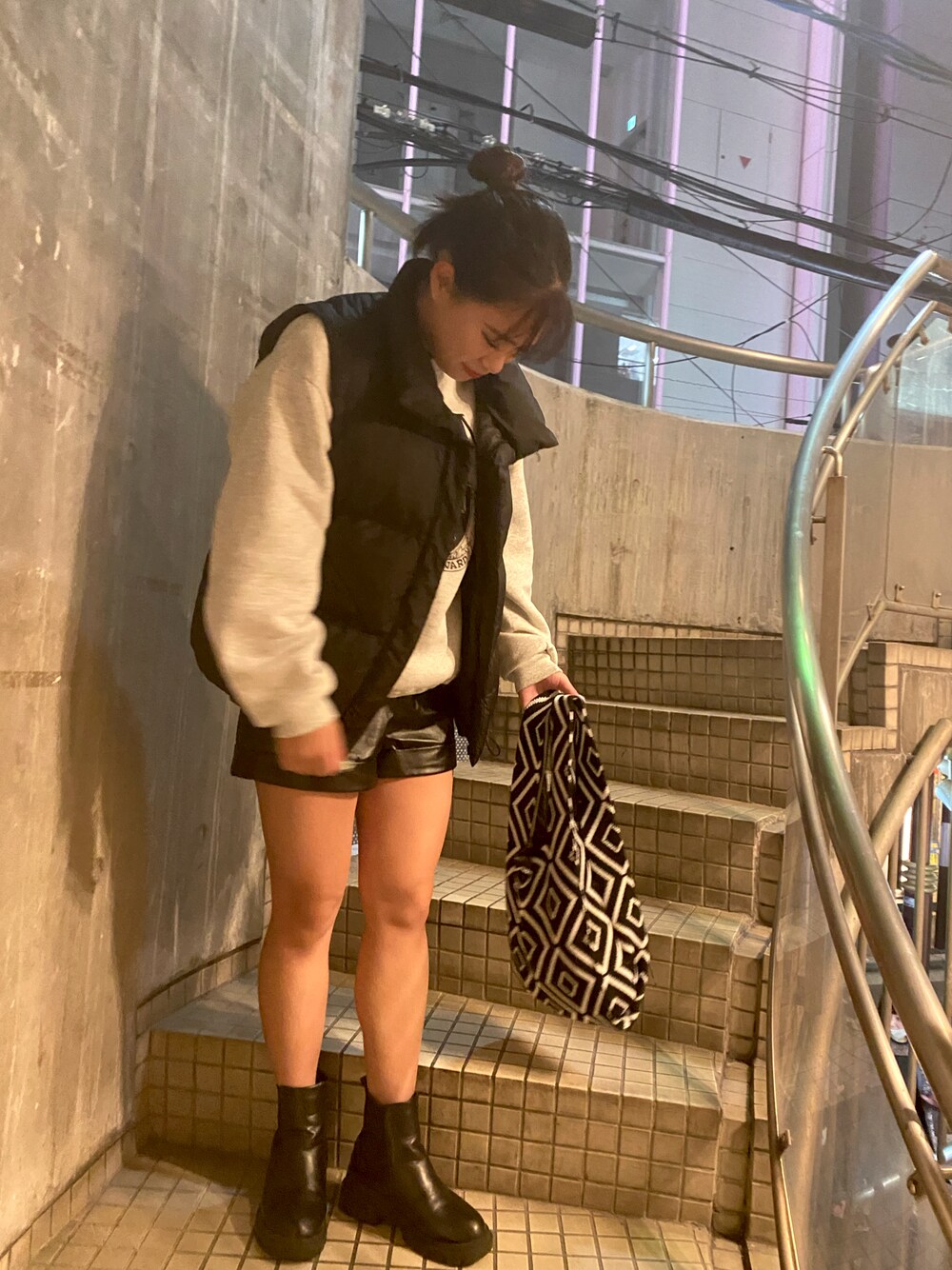 ブラック系のダウンベスト、ブラック系のブーツ、ブラック系のその他パンツを着用したレディースの冬コーディネートの1枚目の写真