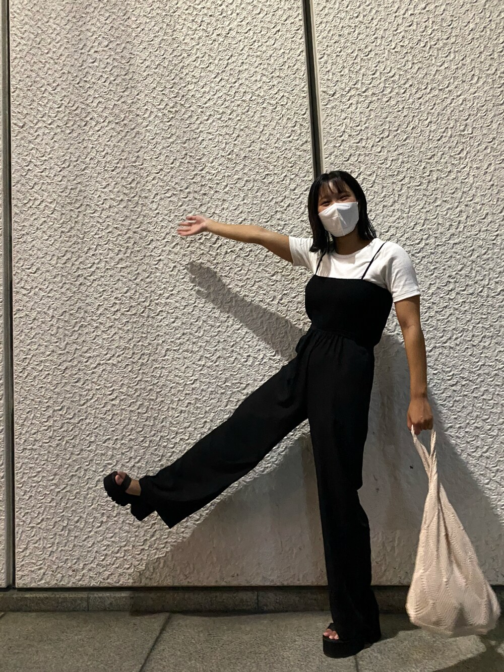 ベージュ系のトートバッグ、ブラック系のオールインワン・サロペット、ブラック系のサンダルを着用したレディースの冬コーディネートの1枚目の写真