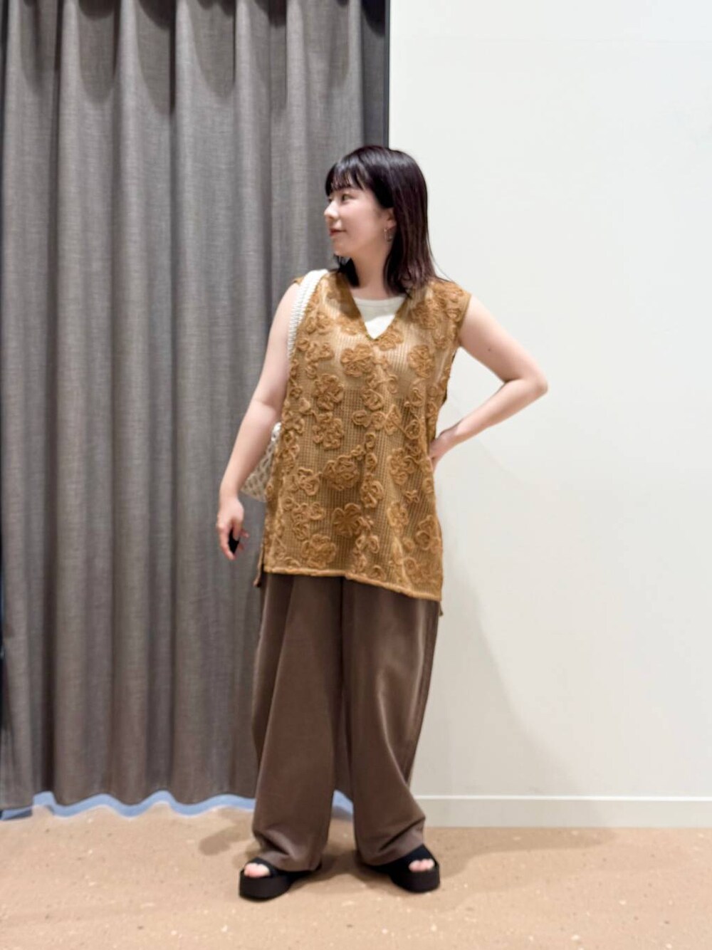 ホワイト系のタンクトップ、ブラック系のサンダル、ホワイト系のトートバッグを着用したレディースの春コーディネートの1枚目の写真