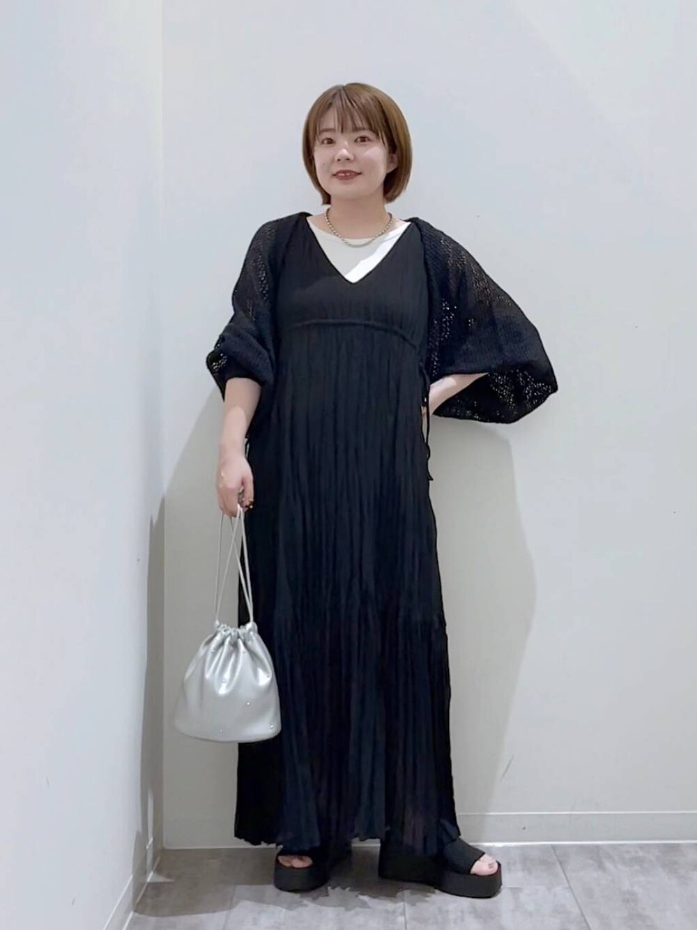 ブラック系のサンダル、シルバー系のショルダーバッグ、ホワイト系のタンクトップを着用したレディースの夏コーディネートの1枚目の写真