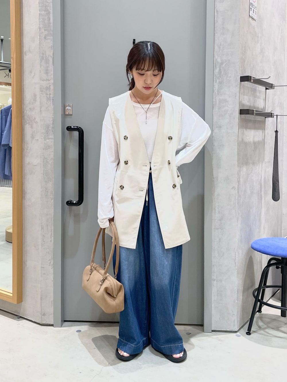 ベージュ系のベスト、ホワイト系のTシャツ/カットソー、ブルー系のデニムパンツを着用したレディースの夏コーディネートの1枚目の写真