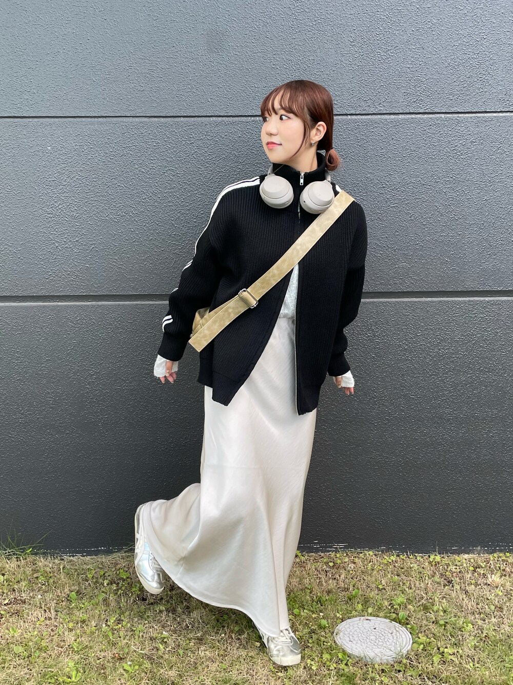 ベージュ系のショルダーバッグ、ホワイト系のスカート、ブラック系のニット/セーターを着用したレディースの秋コーディネートの1枚目の写真