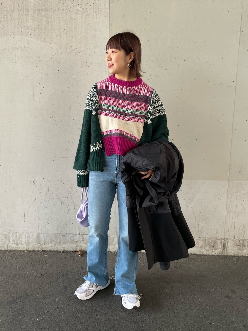 ピンク系のニット/セーター、ブラック系のその他アウター、ブルー系のデニムパンツを着用したレディースの秋コーディネートの1枚目の写真