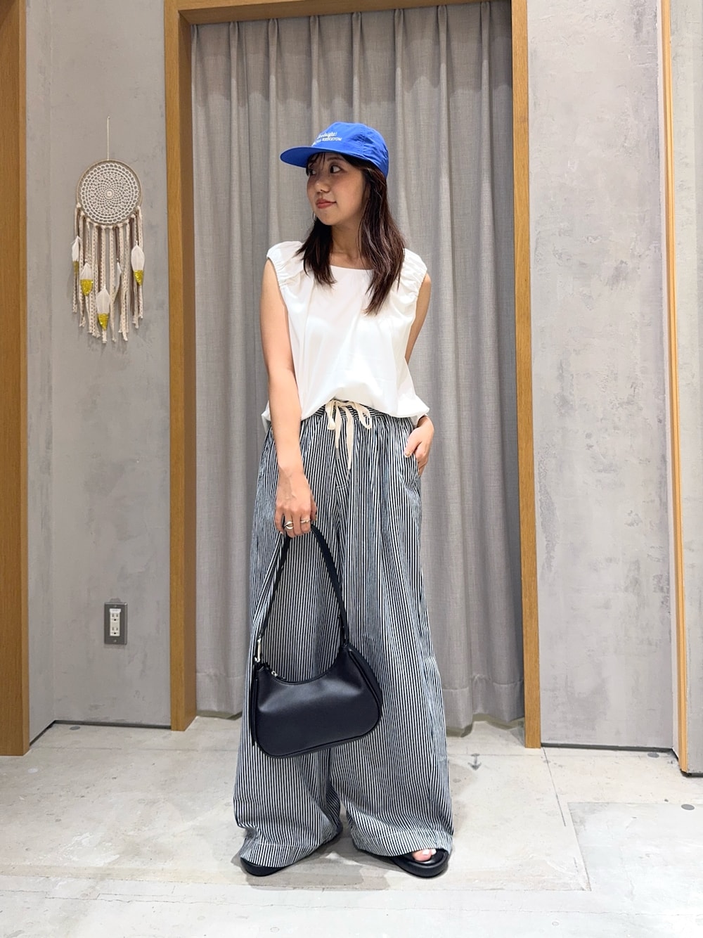 ブルー系のデニムパンツ、ホワイト系のTシャツ/カットソー、ブラック系のトートバッグを着用したレディースの夏コーディネートの1枚目の写真