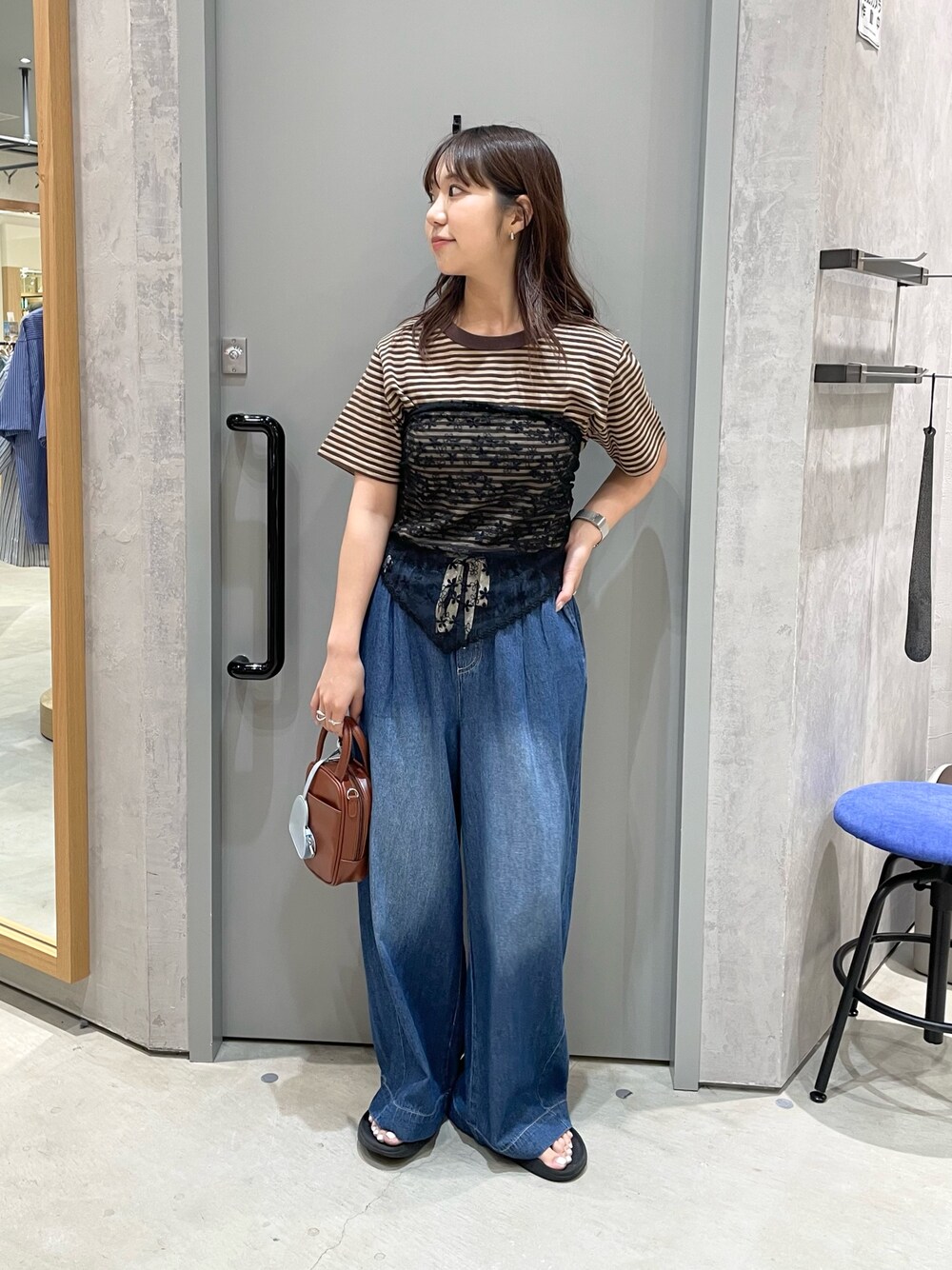 ブルー系のデニムパンツ、ブラウン系のTシャツ/カットソー、ブラウン系のトートバッグを着用したレディースの夏コーディネートの1枚目の写真