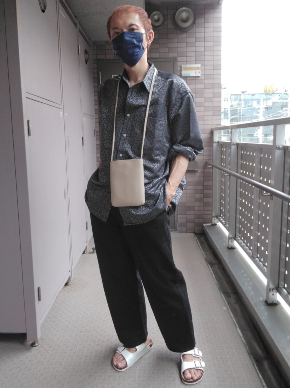 ブラック系のその他パンツ、ホワイト系のサンダル、ホワイト系のショルダーバッグを着用したメンズの夏コーディネートの1枚目の写真