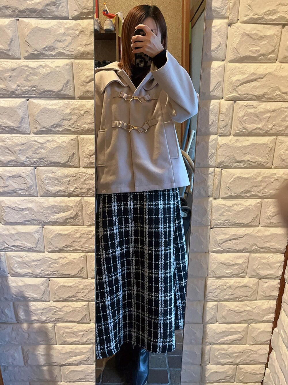 ピンク系のジャケット/アウター、ブラック系のスカート、ブラック系のブーツを着用したレディースの冬コーディネートの1枚目の写真