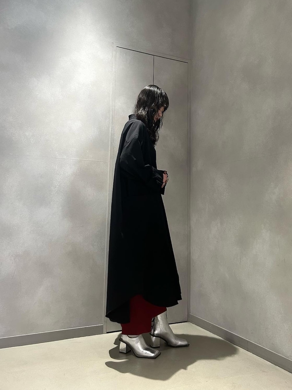 ブラック系のワンピース、レッド系のスカート、シルバー系のブーツを着用したレディースの冬コーディネートの1枚目の写真