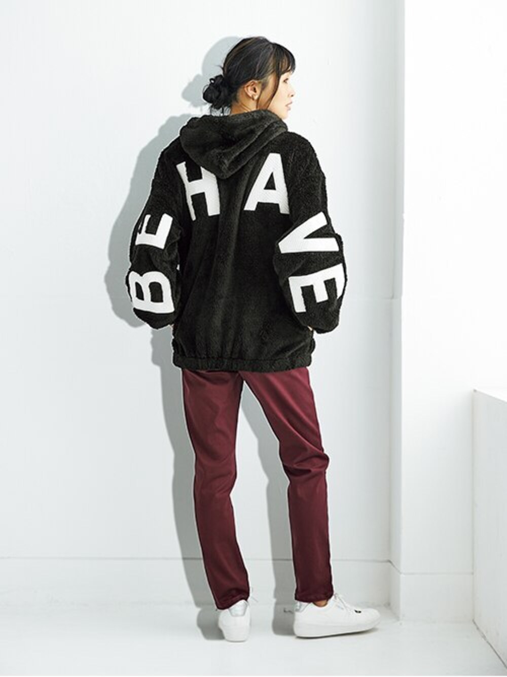 レッド系のデニムパンツ、ブラック系のパーカーを着用したレディースの秋コーディネートの1枚目の写真