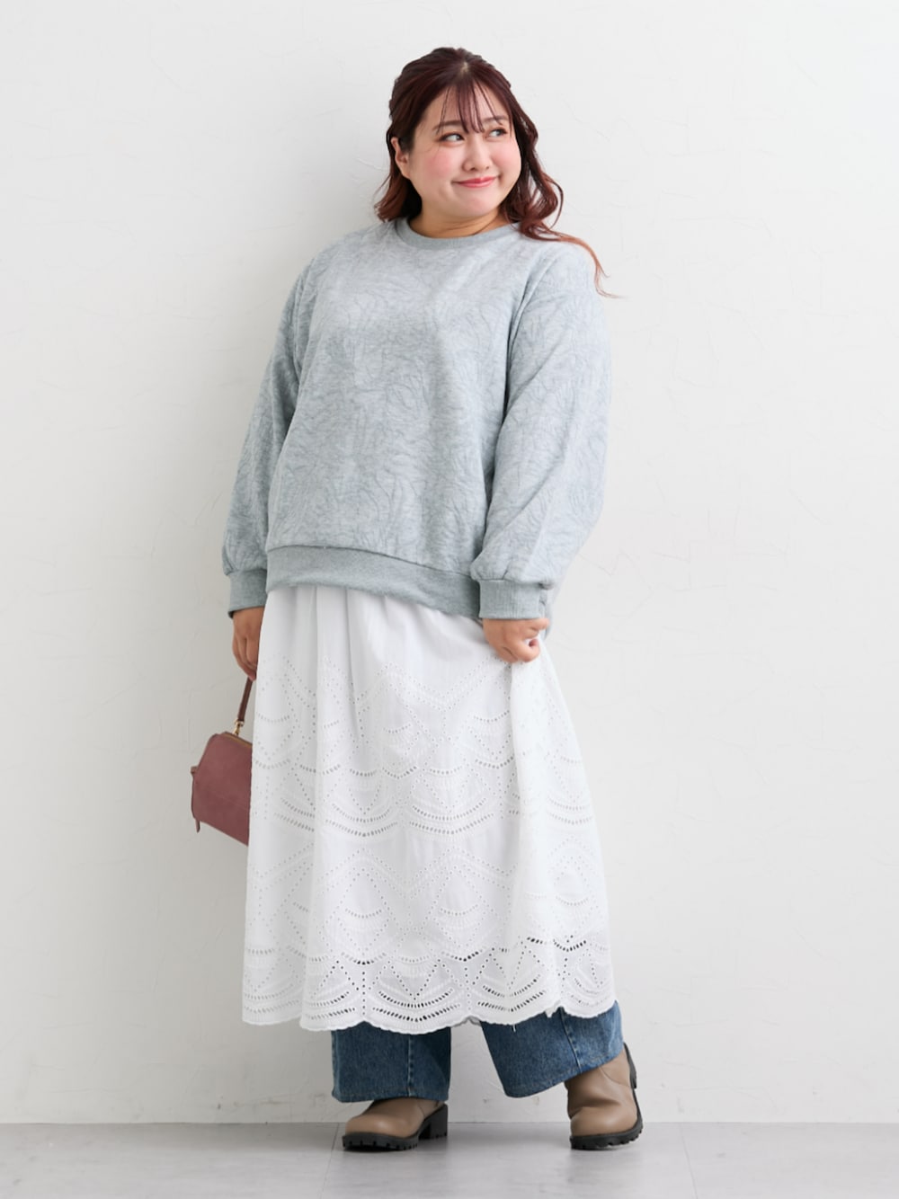 ホワイト系のスカート、グレー系のTシャツ/カットソー、ブルー系のデニムパンツを着用したレディースの秋コーディネートの1枚目の写真