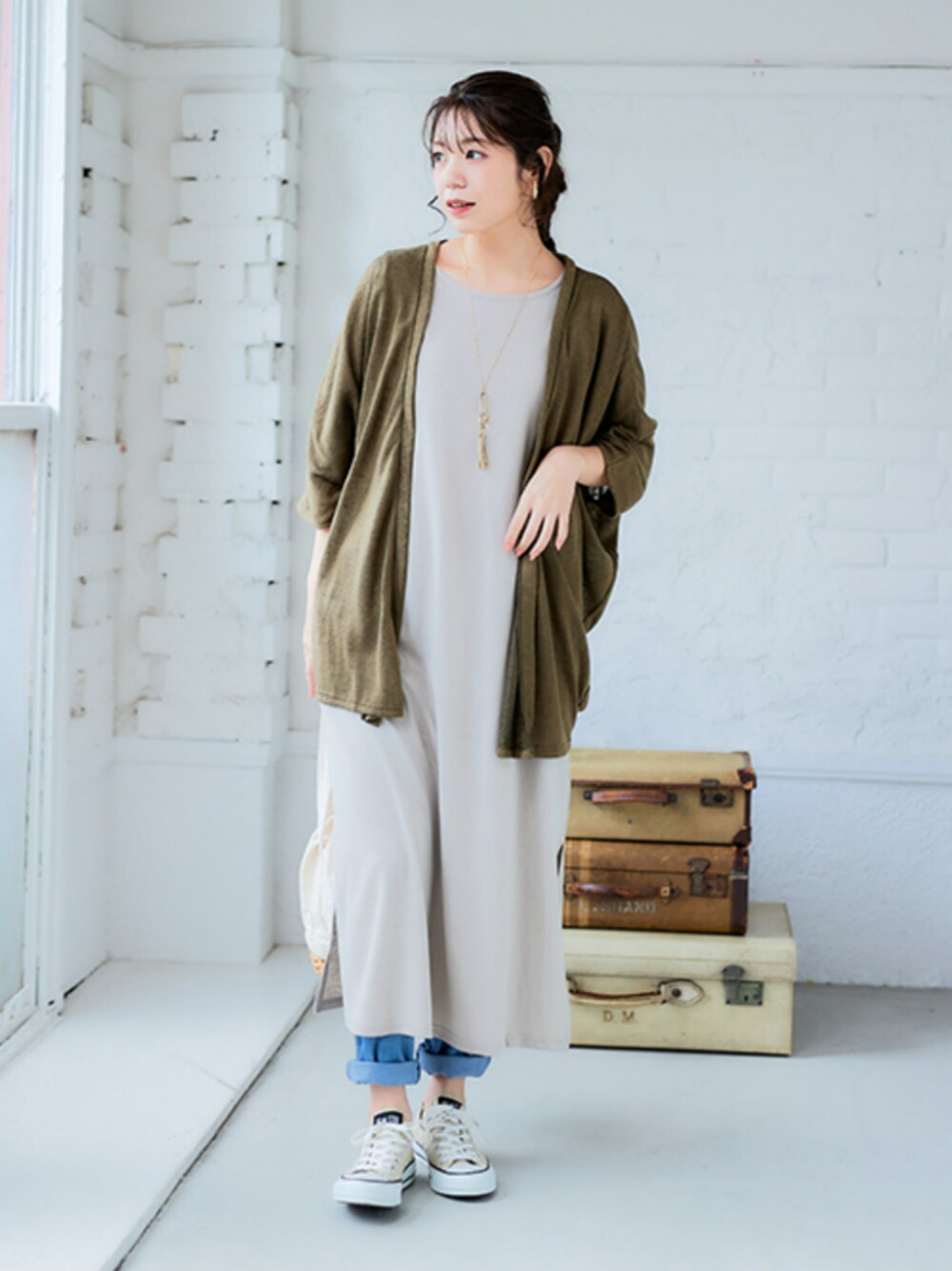 ブルー系のパンツ、ベージュ系のワンピース、グリーン系のカーディガン/ボレロを着用したレディースの春コーディネートの1枚目の写真