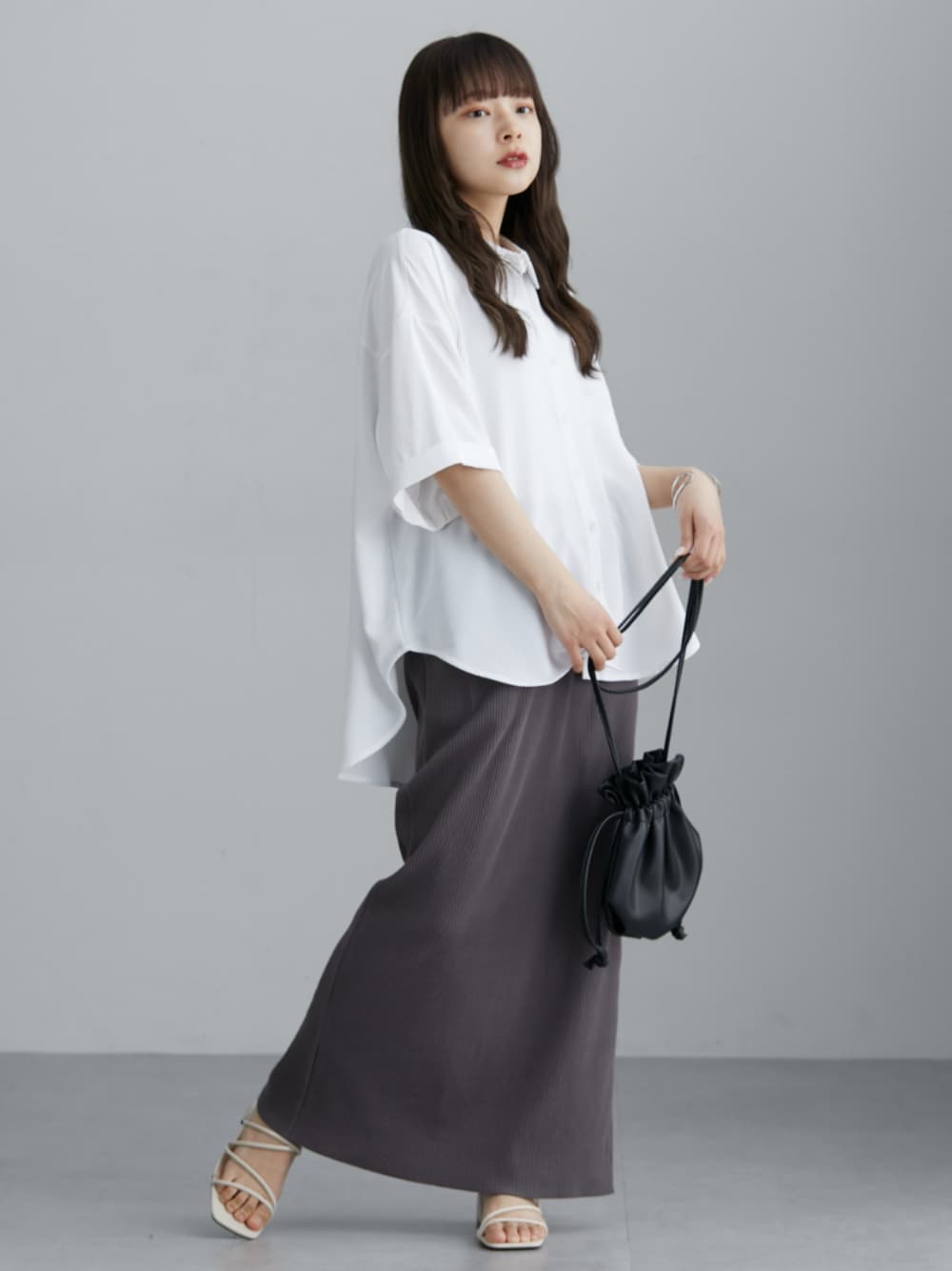 ホワイト系のシャツ/ブラウス、グレー系のスカート、ホワイト系のシャツ/ブラウスを着用したレディースの春コーディネートの1枚目の写真
