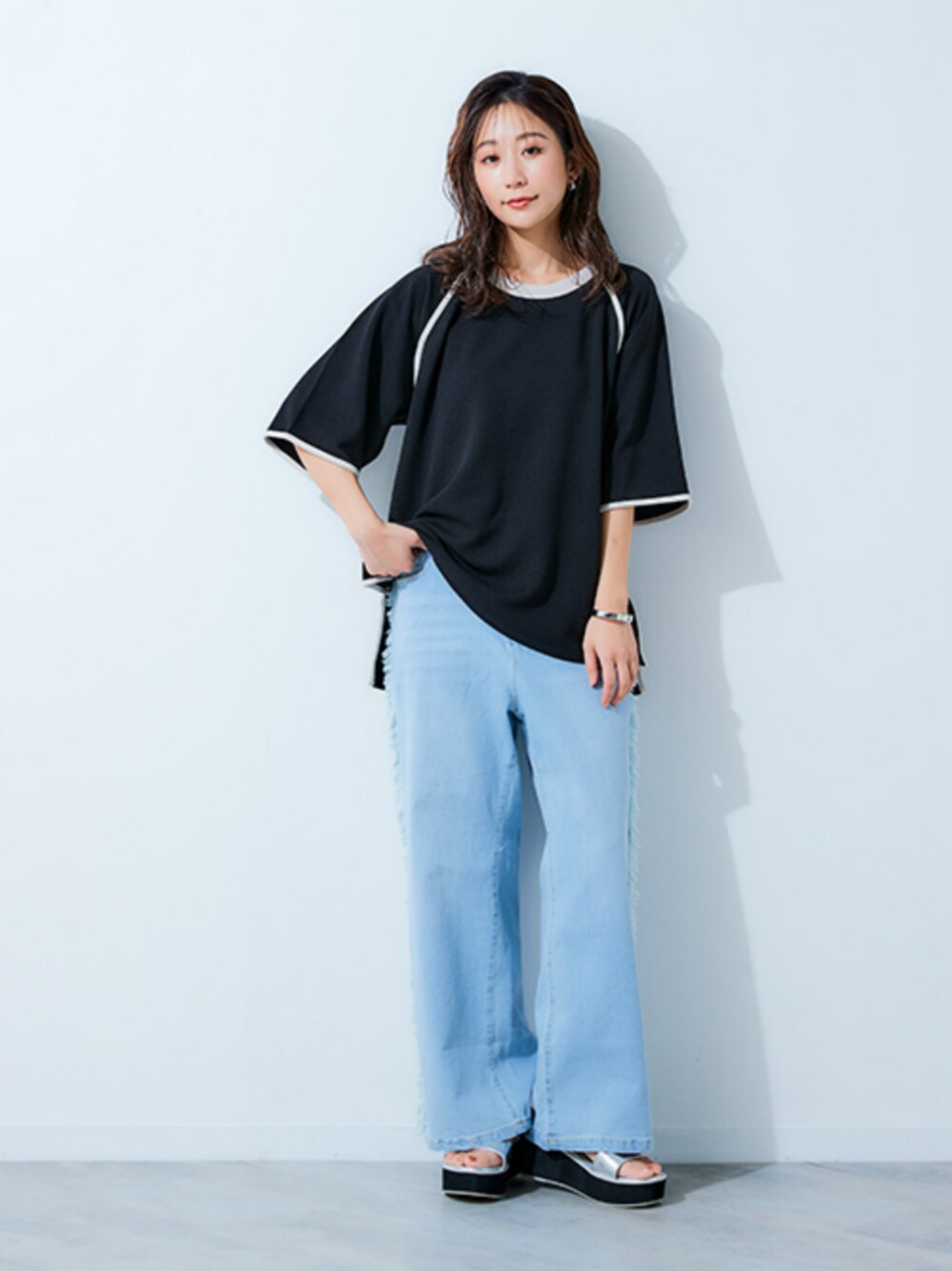 ブルー系のパンツ、ブラック系のTシャツ/カットソーを着用したレディースの春コーディネートの1枚目の写真