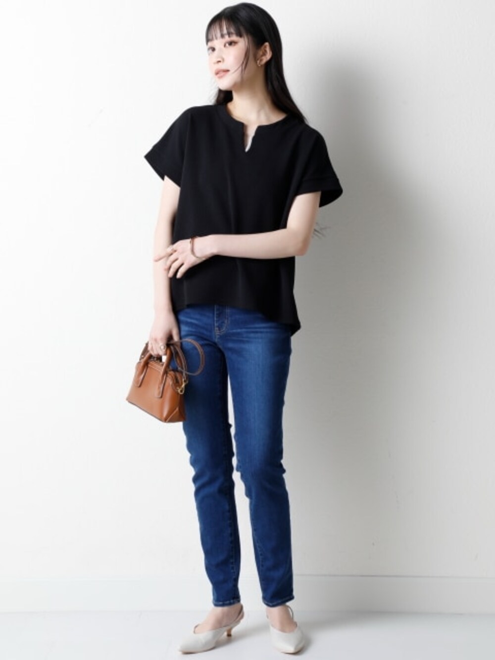 ブルー系のパンツ、ブラック系のTシャツ/カットソーを着用したレディースの春コーディネートの1枚目の写真