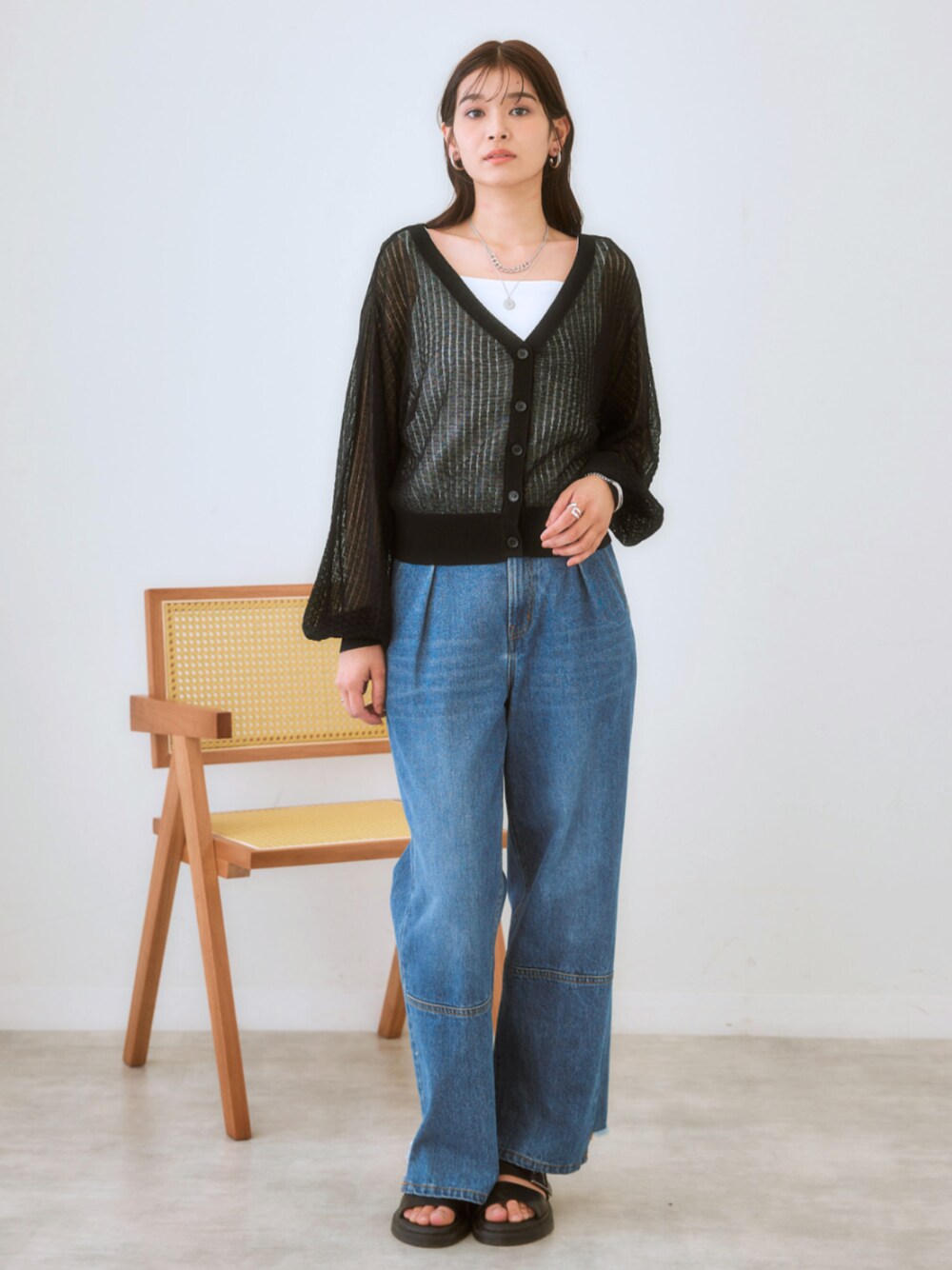 ブルー系のデニムパンツ、ブラック系のカーディガン/ボレロ、ホワイト系のTシャツ/カットソーを着用したレディースの春コーディネートの1枚目の写真