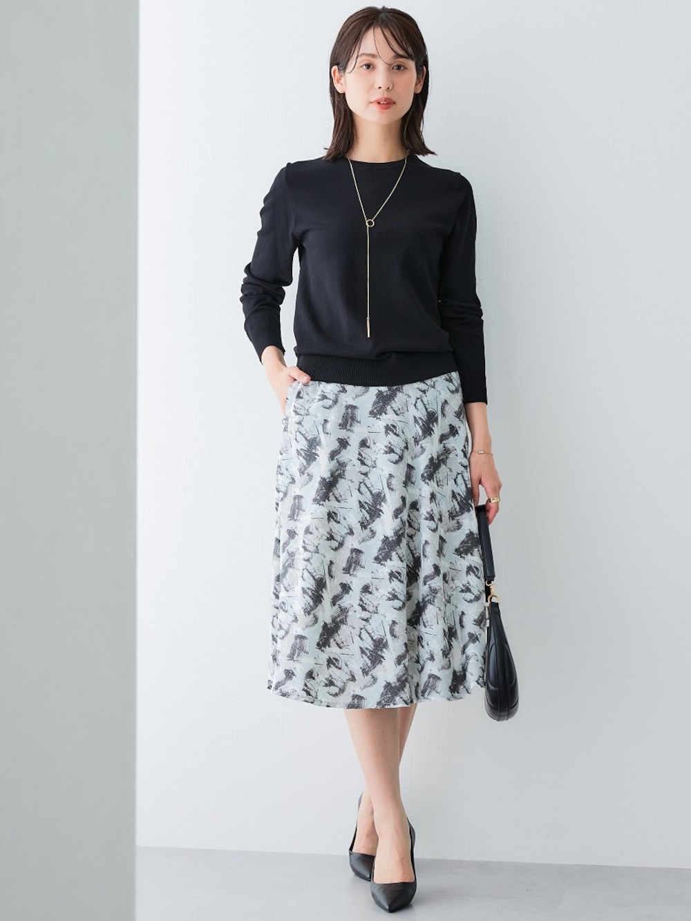 ブラック系のスカート、ブラック系のニット/セーターを着用したレディースの夏コーディネートの1枚目の写真