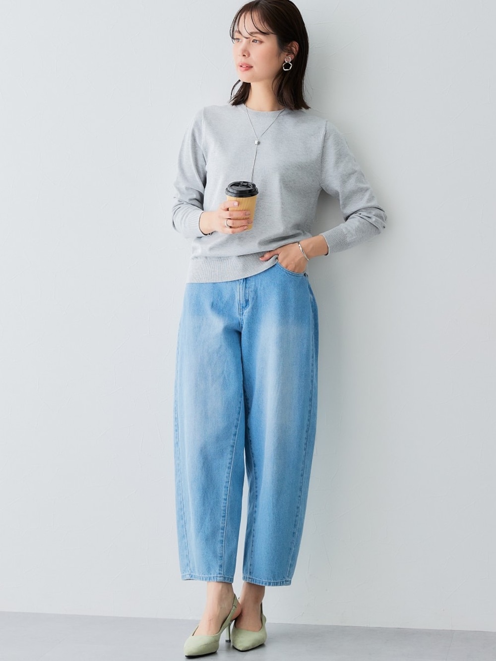 ブルー系のデニムパンツ、グレー系のニット/セーターを着用したレディースの夏コーディネートの1枚目の写真