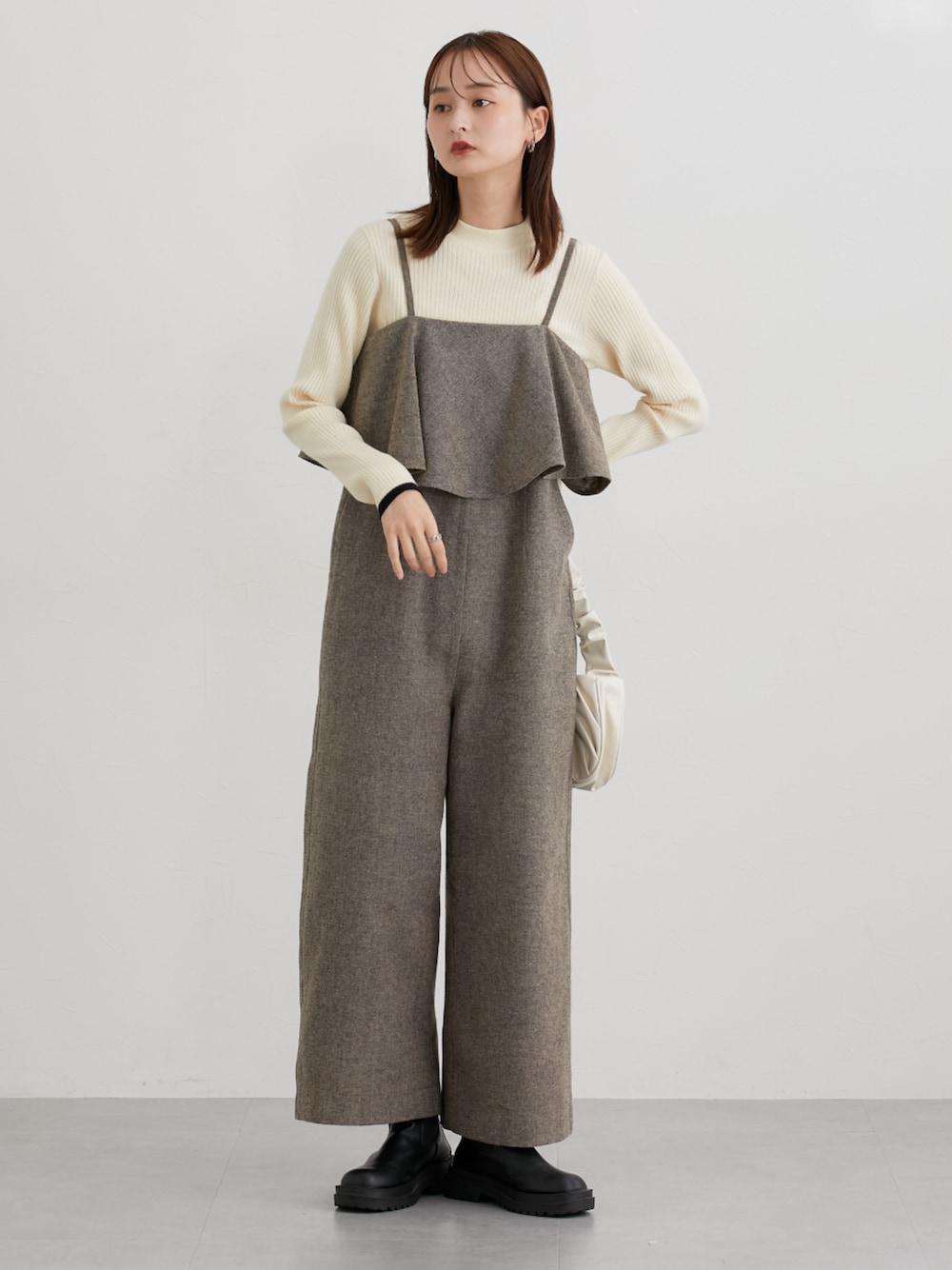 ベージュ系のニット/セーター、ベージュ系のつなぎ/オールインワンを着用したレディースの秋コーディネートの1枚目の写真