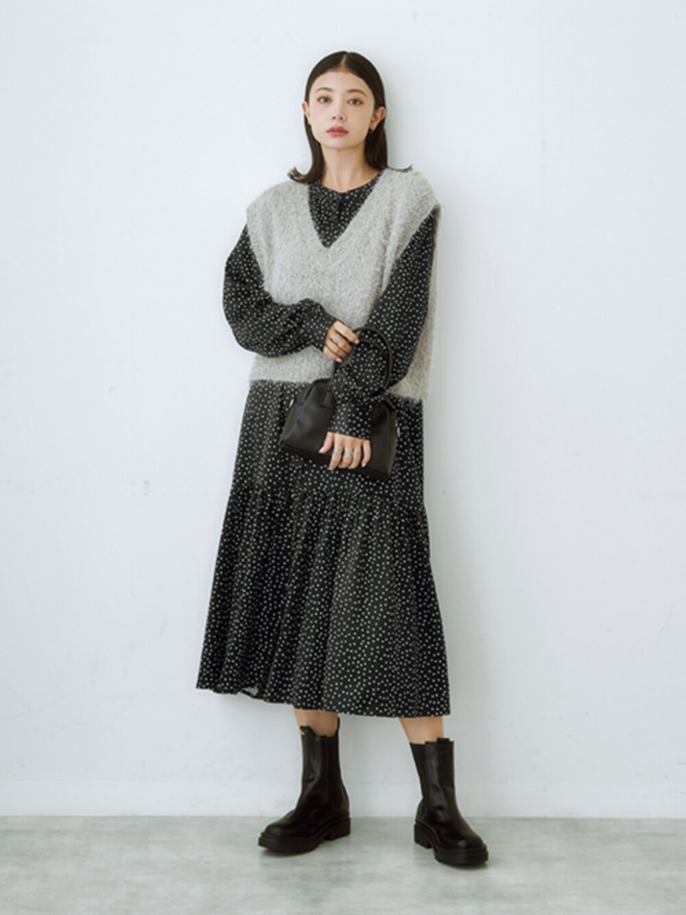 ブラック系のワンピース、シルバー系のベストを着用したレディースの冬コーディネートの1枚目の写真