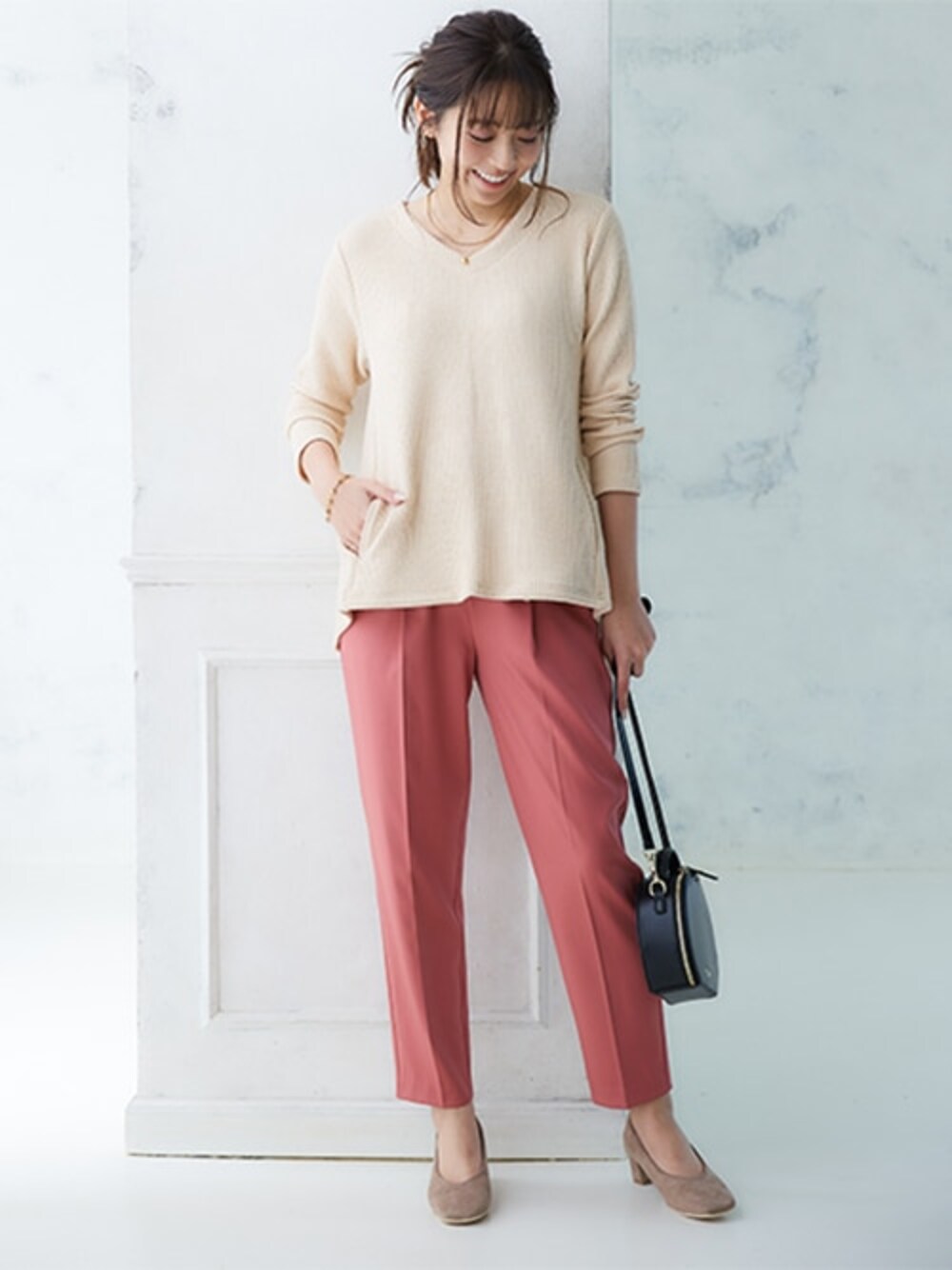 ピンク系のスラックス、ベージュ系のTシャツ/カットソーを着用したレディースの夏コーディネートの1枚目の写真
