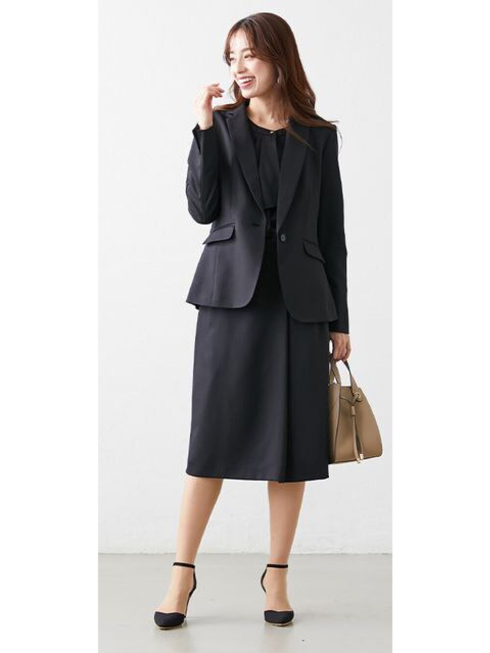 ブラック系のスーツセットを着用したレディースの春コーディネートの1枚目の写真