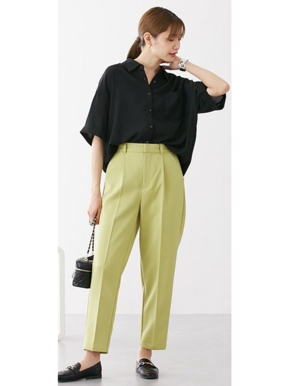 グリーン系のパンツ、ブラック系のシャツ/ブラウスを着用したレディースの春コーディネートの1枚目の写真