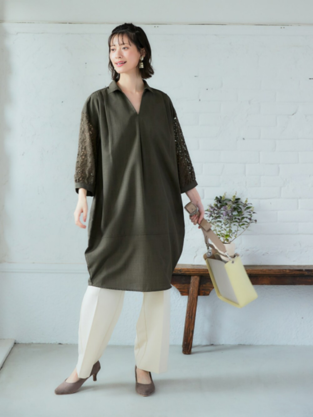 グリーン系のワンピース、ホワイト系のパンツを着用したレディースの冬コーディネートの1枚目の写真