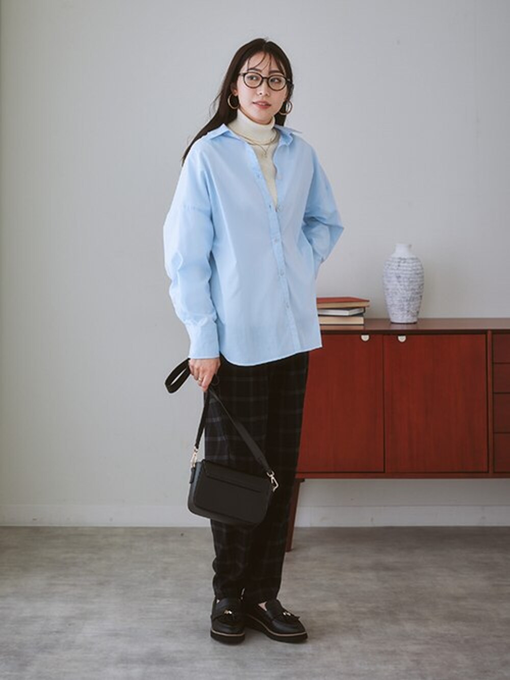 ブルー系のシャツ/ブラウス、ホワイト系のニット/セーター、ブラック系のローファーを着用したレディースの秋コーディネートの1枚目の写真