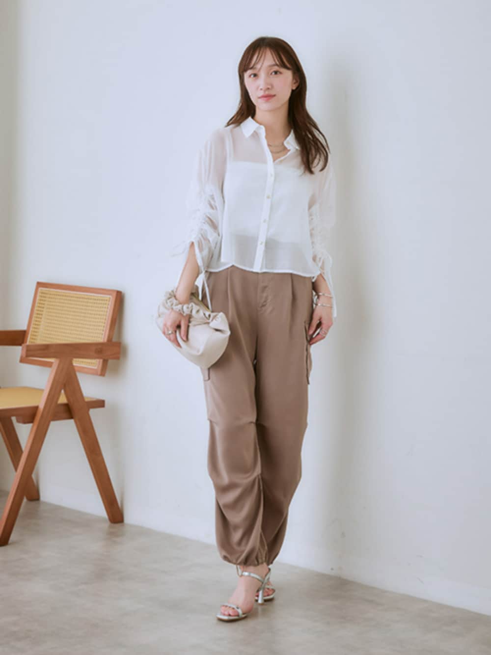ホワイト系のシャツ/ブラウス、ベージュ系のカーゴパンツを着用したレディースの春コーディネートの1枚目の写真
