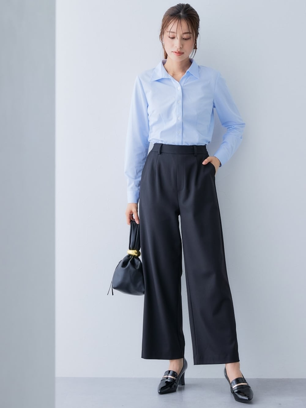 ブルー系のシャツ/ブラウス、ブラック系のパンツを着用したレディースの秋コーディネートの1枚目の写真