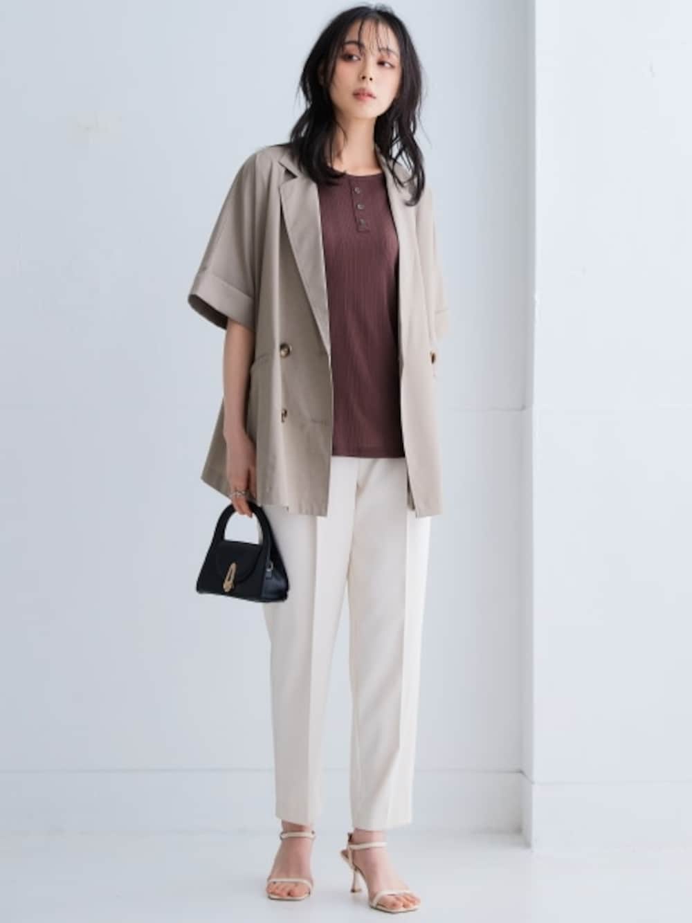 ベージュ系のスラックス、ブラウン系のTシャツ/カットソー、ベージュ系のテーラードジャケットを着用したレディースの春コーディネートの1枚目の写真