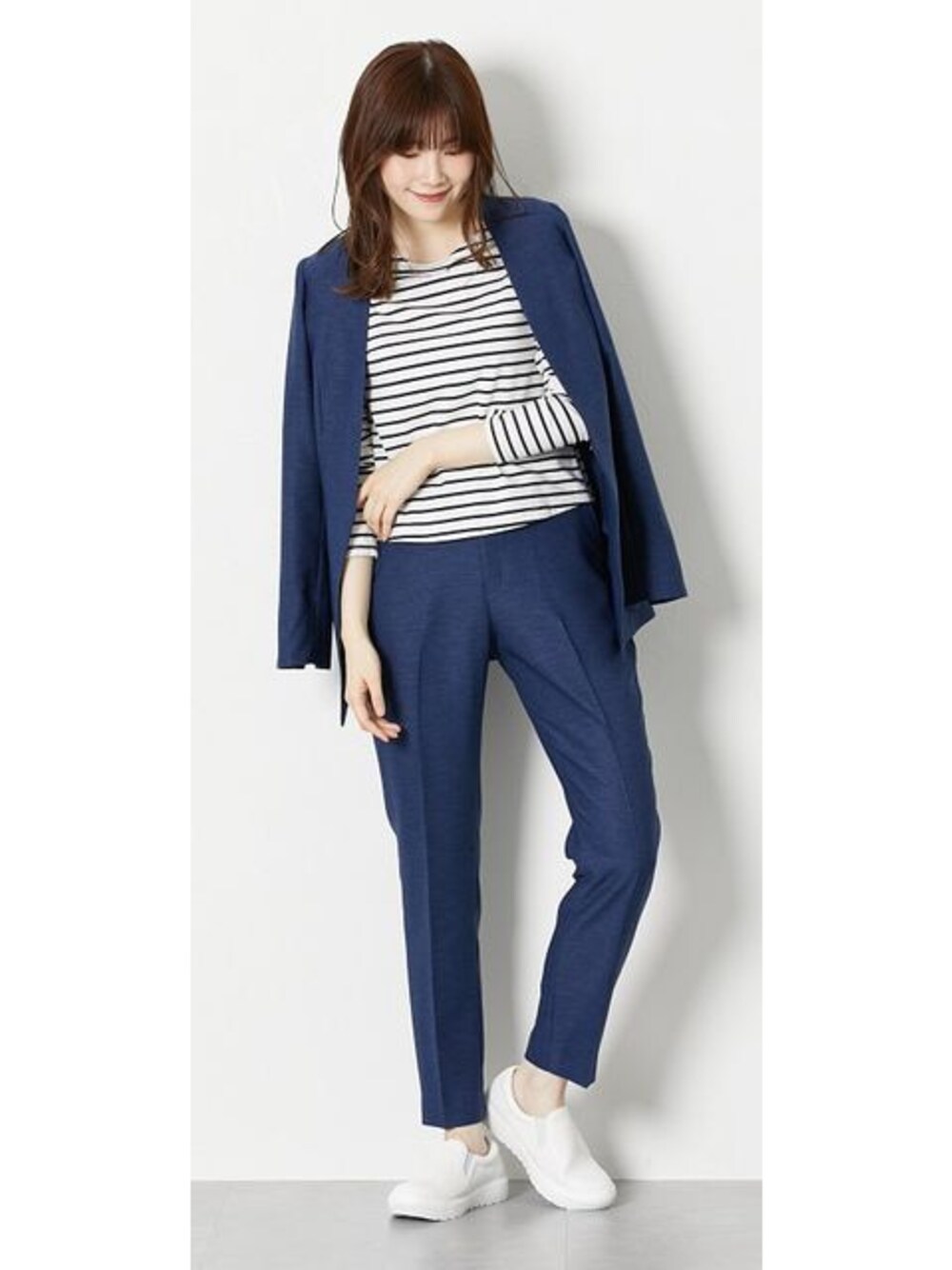 ホワイト系のスニーカー、ブルー系のスーツセットを着用したレディースの春コーディネートの1枚目の写真