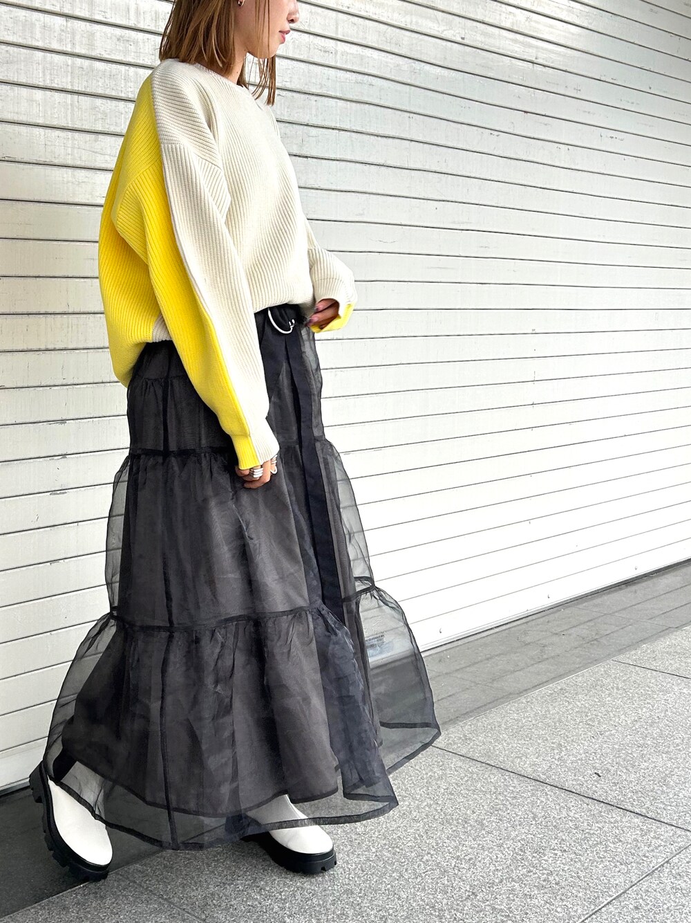 ホワイト系のブーツ、ブラック系のスカート、ホワイト系のニット/セーターを着用したレディースの夏コーディネートの1枚目の写真