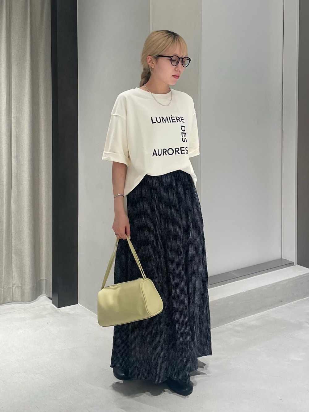 ブラック系のその他シューズ、ブラック系のスカート、ベージュ系のTシャツ/カットソーを着用したレディースの夏コーディネートの1枚目の写真