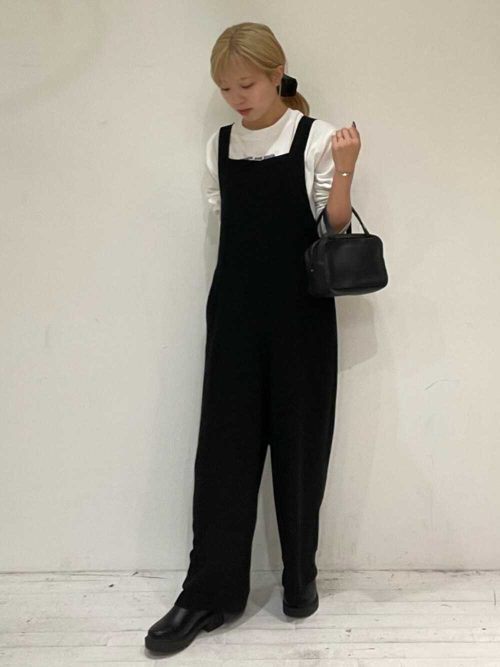 ブルー系のTシャツ/カットソー、ブラック系のボストンバッグ、ブラック系のブーツを着用したレディースの秋コーディネートの1枚目の写真